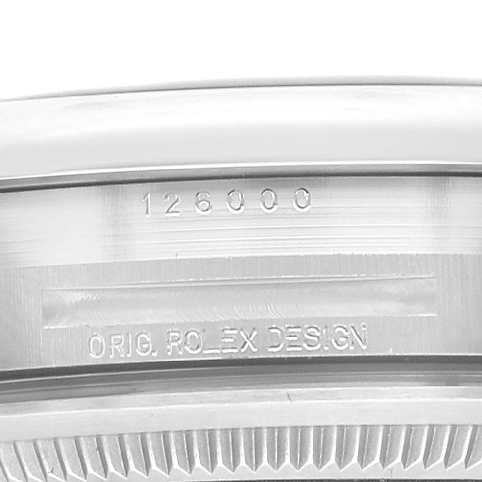 This image shows a close-up of the engraved model number and "Orig. Rolex Design" writing on the side of the Rolex Oyster Perpetual 126000 Men
s Stainless Steel Blue Dial 126000 Men
s Stainless Steel Blue Dial watch case.