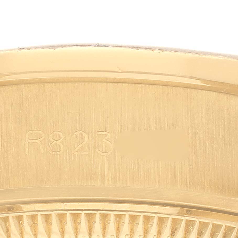 The image shows a close-up of the engraved side view of a Rolex President 69288 Women's Yellow Gold Champagne Dial 69288 Women's Yellow Gold Champagne Dial model caseback.