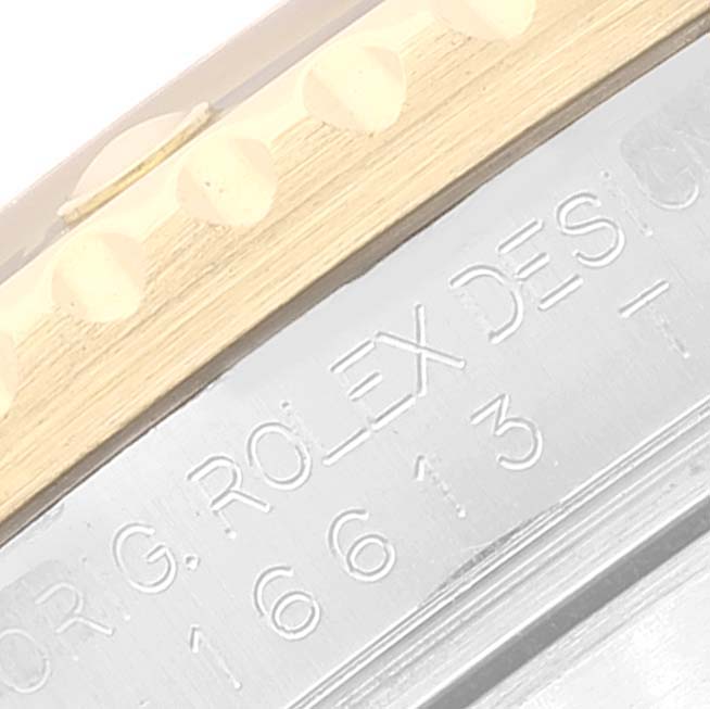 The image shows a close-up of the Rolex Submariner 16613 Men's Steel and Gold (two tone) Blue Dial 16613 Men's Steel and Gold (two tone) Blue Dial's engraved side and part of the bezel.