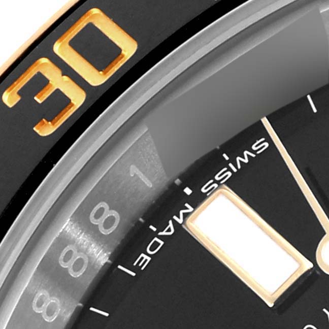The image shows a close-up of the Rolex Submariner 116613 Men's Steel and Gold (two tone) Black Dial 116613 Men's Steel and Gold (two tone) Black Dial’s bezel, dial, and hour markers at an angled view.