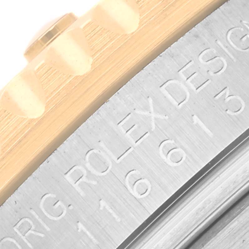 The image shows a close-up of the bezel and engraved side of a Rolex Submariner 116613 Men's Steel and Gold (two tone) Black Dial 116613 Men's Steel and Gold (two tone) Black Dial watch.