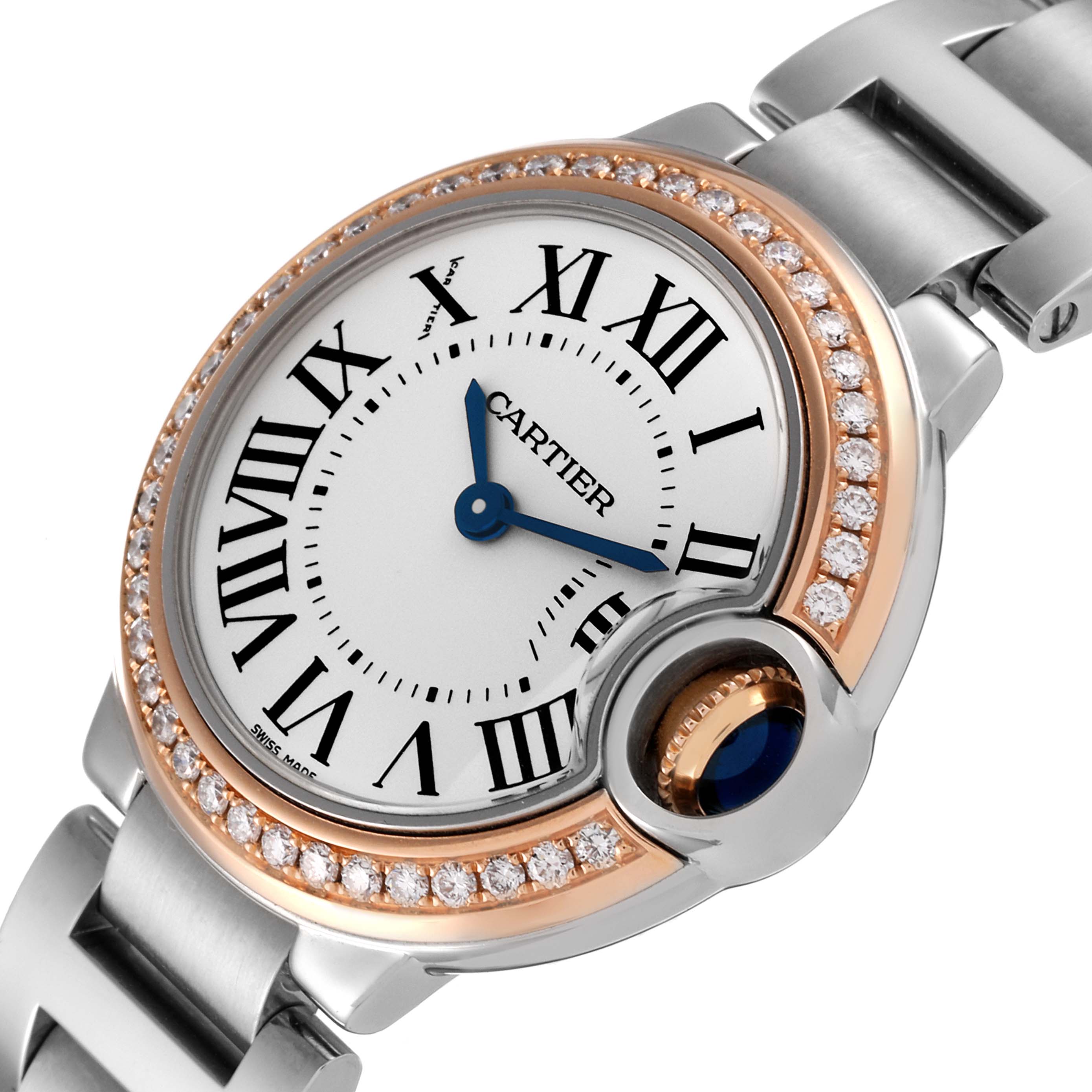 The image shows a close-up of the Cartier Ballon Bleu WE902079 Women's Steel and Gold (two tone) Silver Dial WE902079 Women's Steel and Gold (two tone) Silver Dial watch face, highlighting its Roman numerals, blue hands, and diamond-studded bezel.