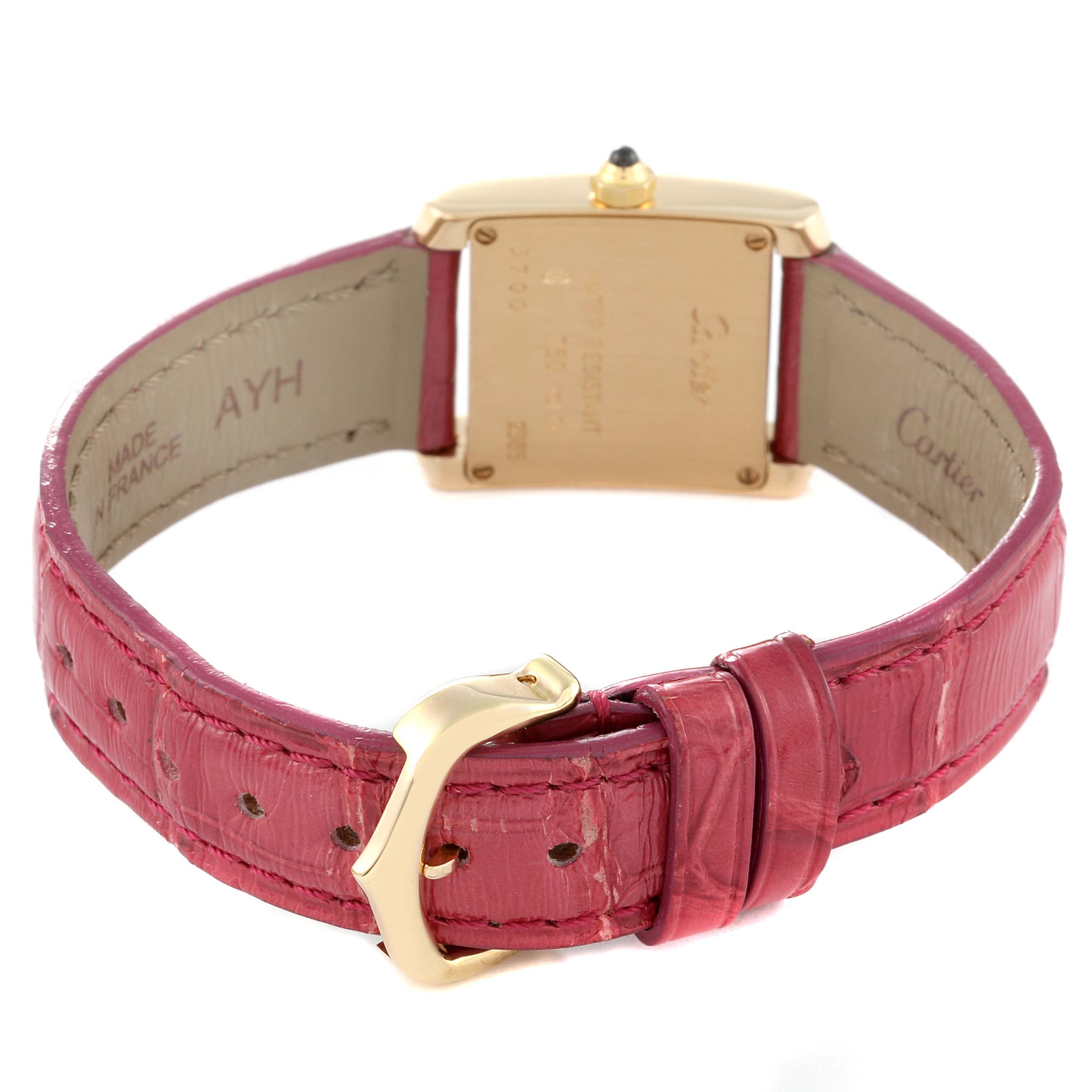 The image shows the back of a Cartier Tank Francaise W5000256 Women
s Yellow Gold Silver Dial W5000256 Women
s Yellow Gold Silver Dial watch with a pink leather strap and gold clasp.