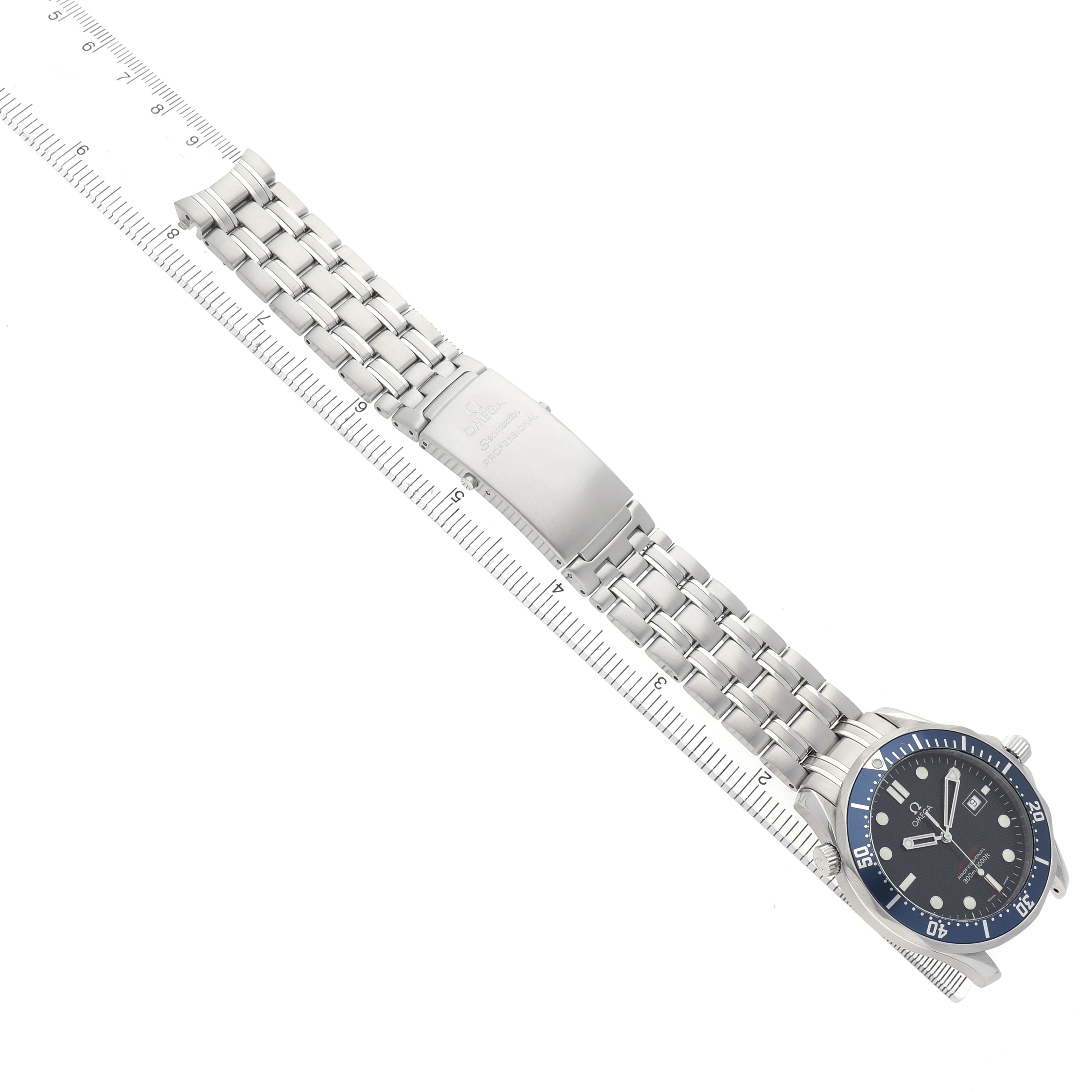 The Omega Seamaster 2221.80.00 Men's Stainless Steel Blue Dial watch is shown laid flat, highlighting the face, bezel, bracelet, and clasp alongside a measuring ruler.