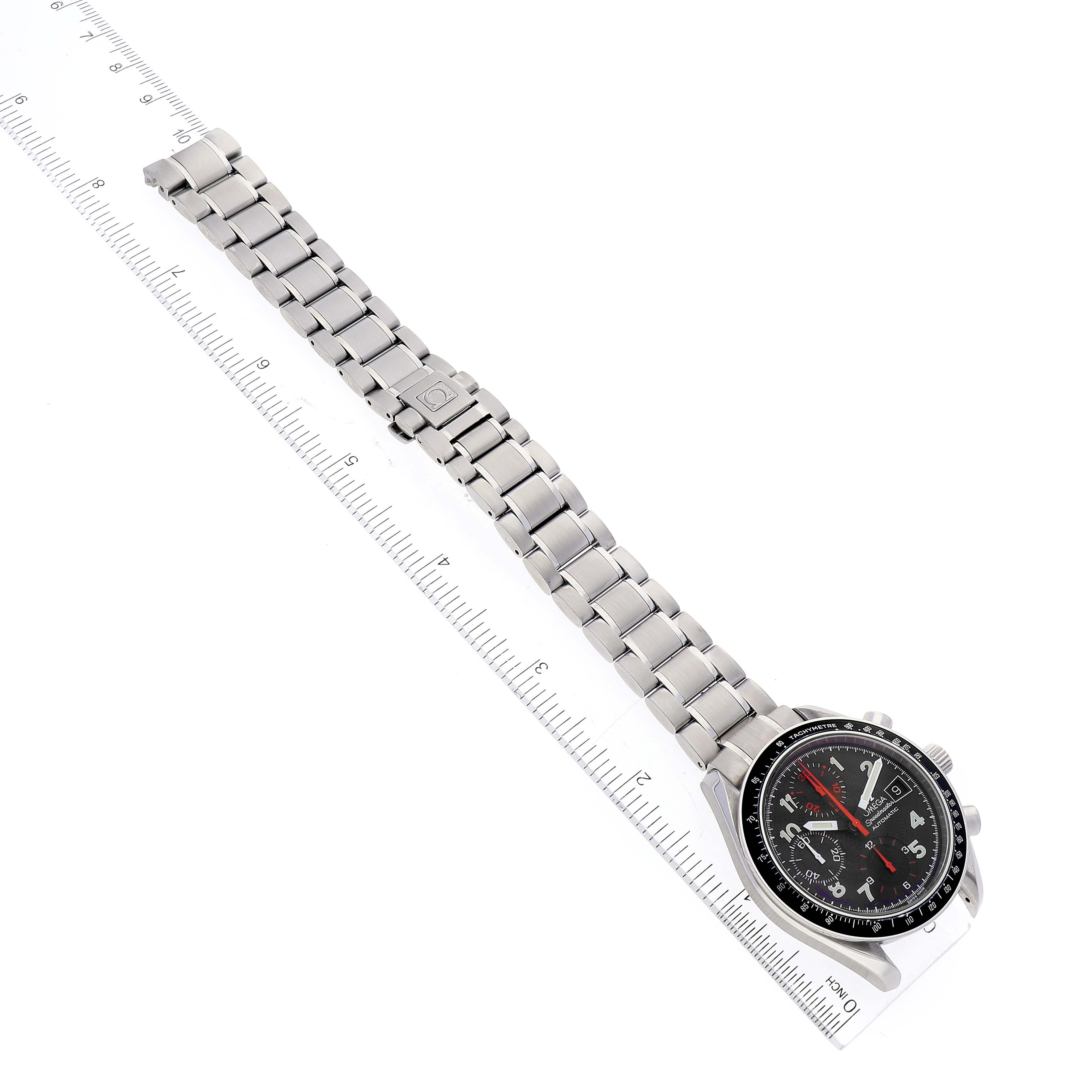 This image shows an Omega Speedmaster 3513.53.00 Men's Stainless Steel Black Dial 3513.53.00 Men's Stainless Steel Black Dial watch, including the full bracelet and dial, laid next to a ruler for scale.