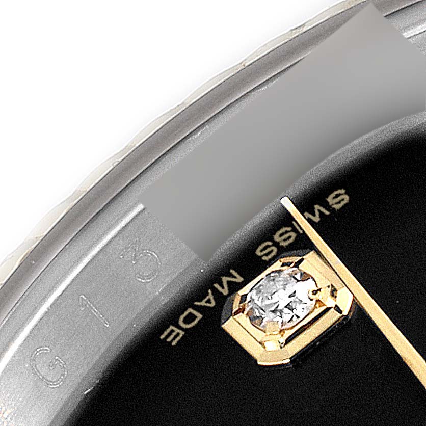 This close-up image of the Rolex Datejust 116233 Men's Steel and Gold (two tone) Black Dial 116233 Men's Steel and Gold (two tone) Black Dial watch shows part of the bezel, a diamond hour marker, and "SWISS MADE" text.