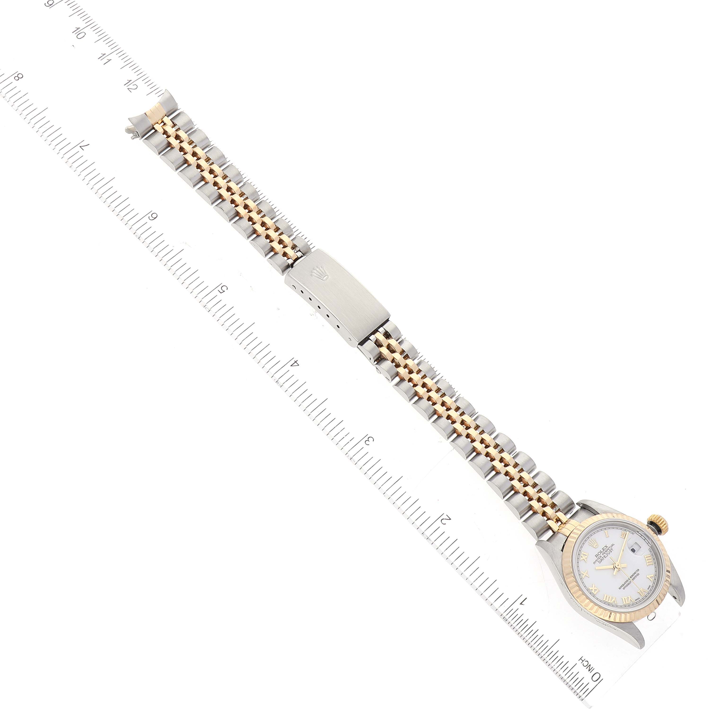 The image shows a Rolex Datejust 79173 Women's Steel and Gold (two tone) White Dial 79173 Women's Steel and Gold (two tone) White Dial watch laid flat with a two-tone bracelet and a ruler for scale.