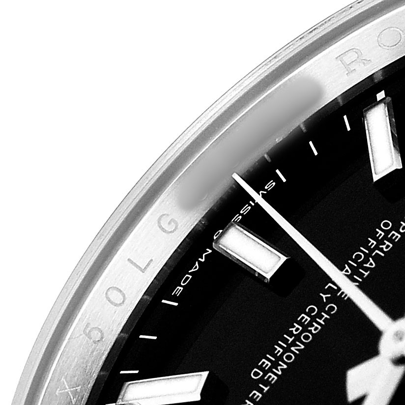 The image shows a close-up of the Rolex Datejust 126200 Men's Stainless Steel Black Dial watch, highlighting the dial, bezel, hour markers, and part of the minute hand.