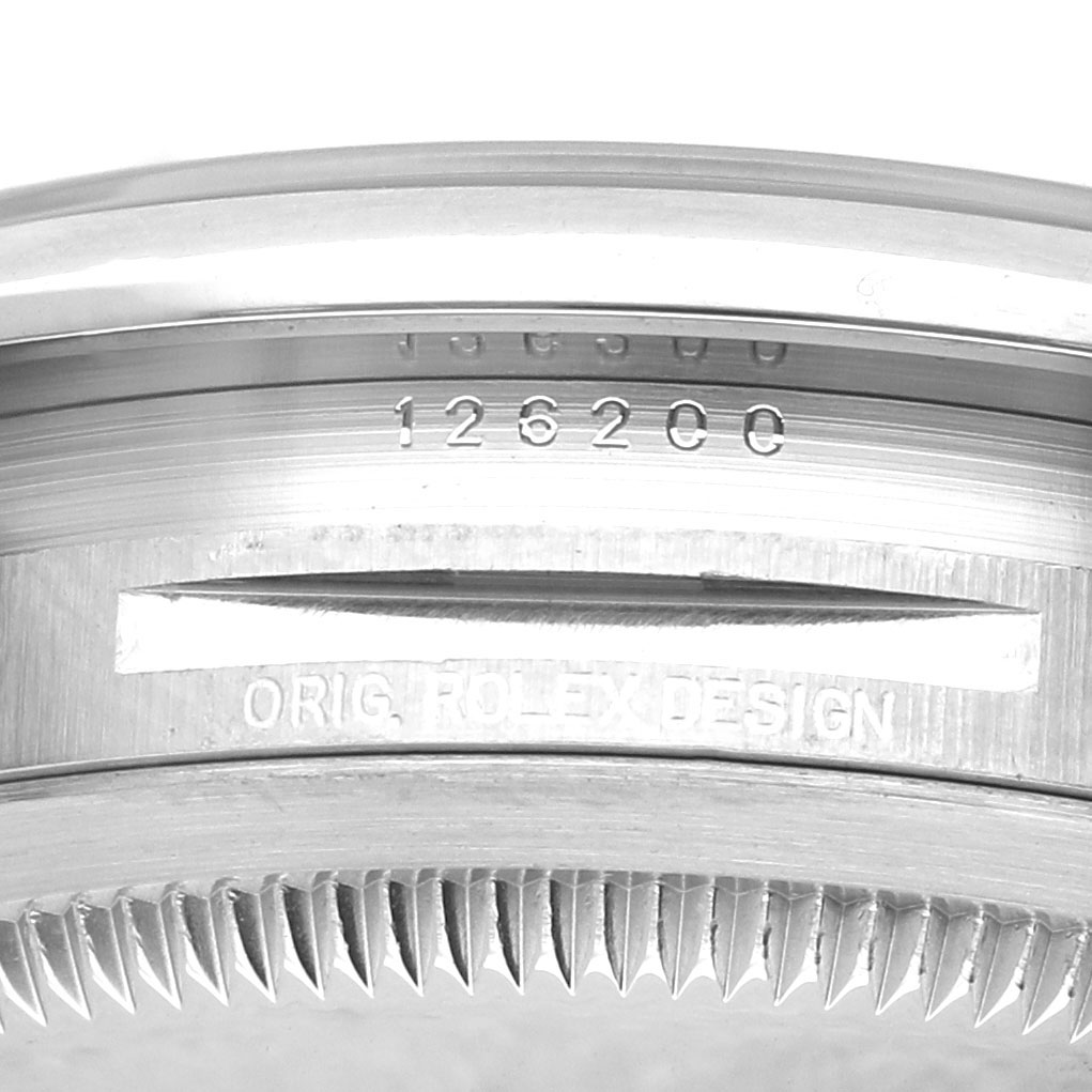 The image shows a close-up of the case side, bezel, and reference number of a Rolex Datejust 126200 Men's Stainless Steel Black Dial watch, with visible engravings.