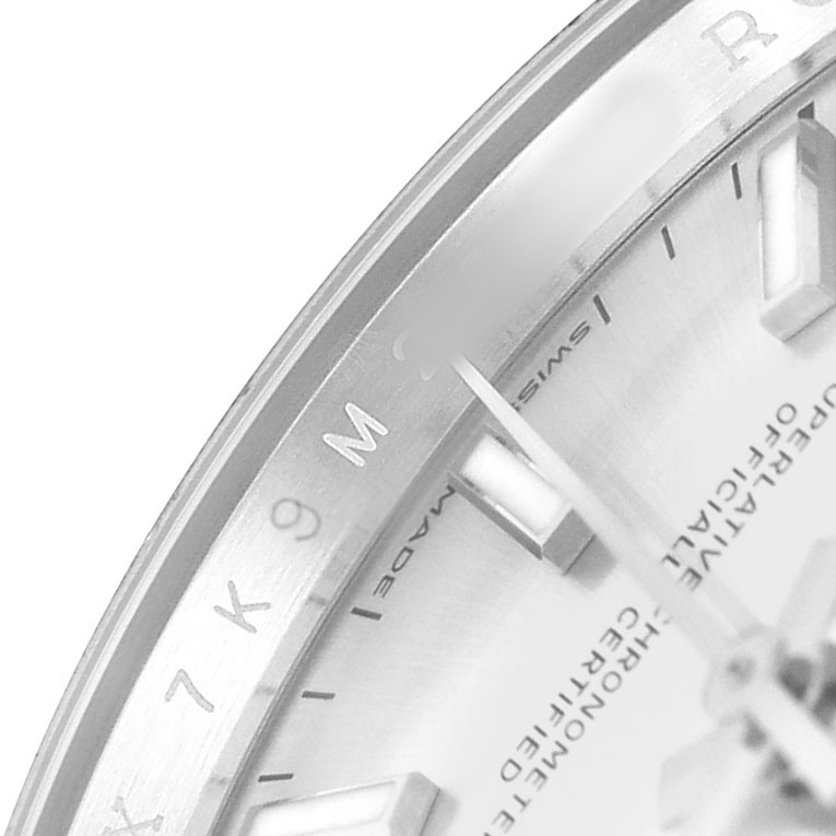 The image shows a close-up of the Rolex Datejust 126200 Men's Stainless Steel Silver Dial watch, highlighting part of the dial, indices, and bezel with text details.