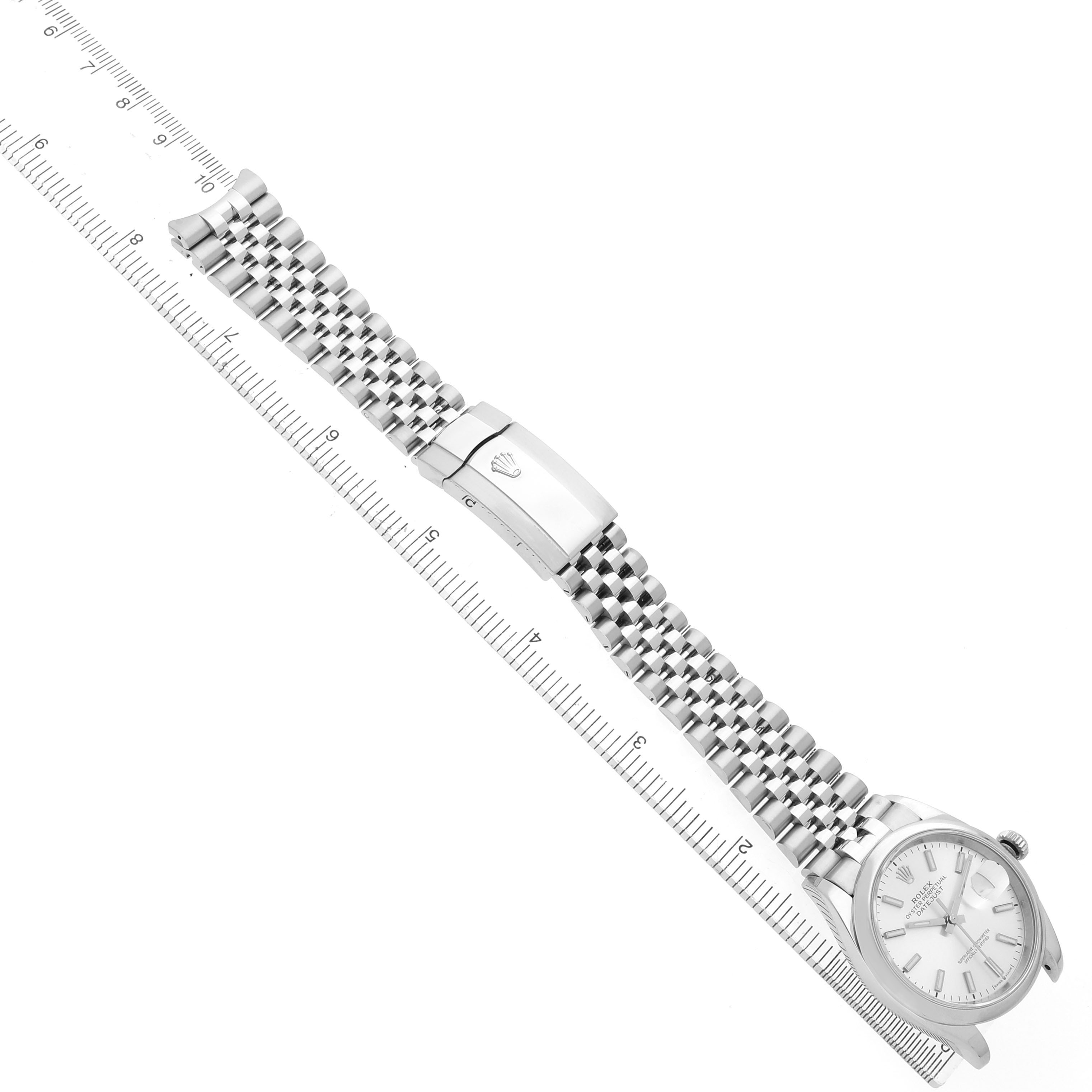 The Rolex Datejust 126200 Men's Stainless Steel Silver Dial watch is shown laid flat with its bracelet extended alongside a ruler for scale.