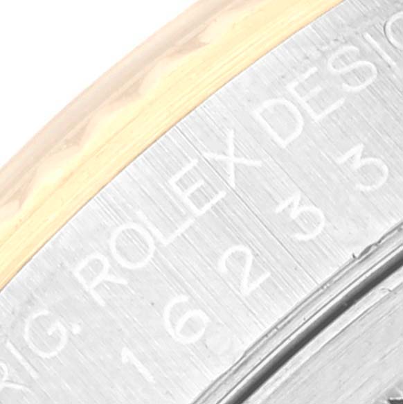 The image shows a close-up of the inner bezel and part of the gold edge on a Rolex Datejust 16233 Men's Steel and Gold (two tone) Black Dial 16233 Men's Steel and Gold (two tone) Black Dial watch, displaying the engraved text.