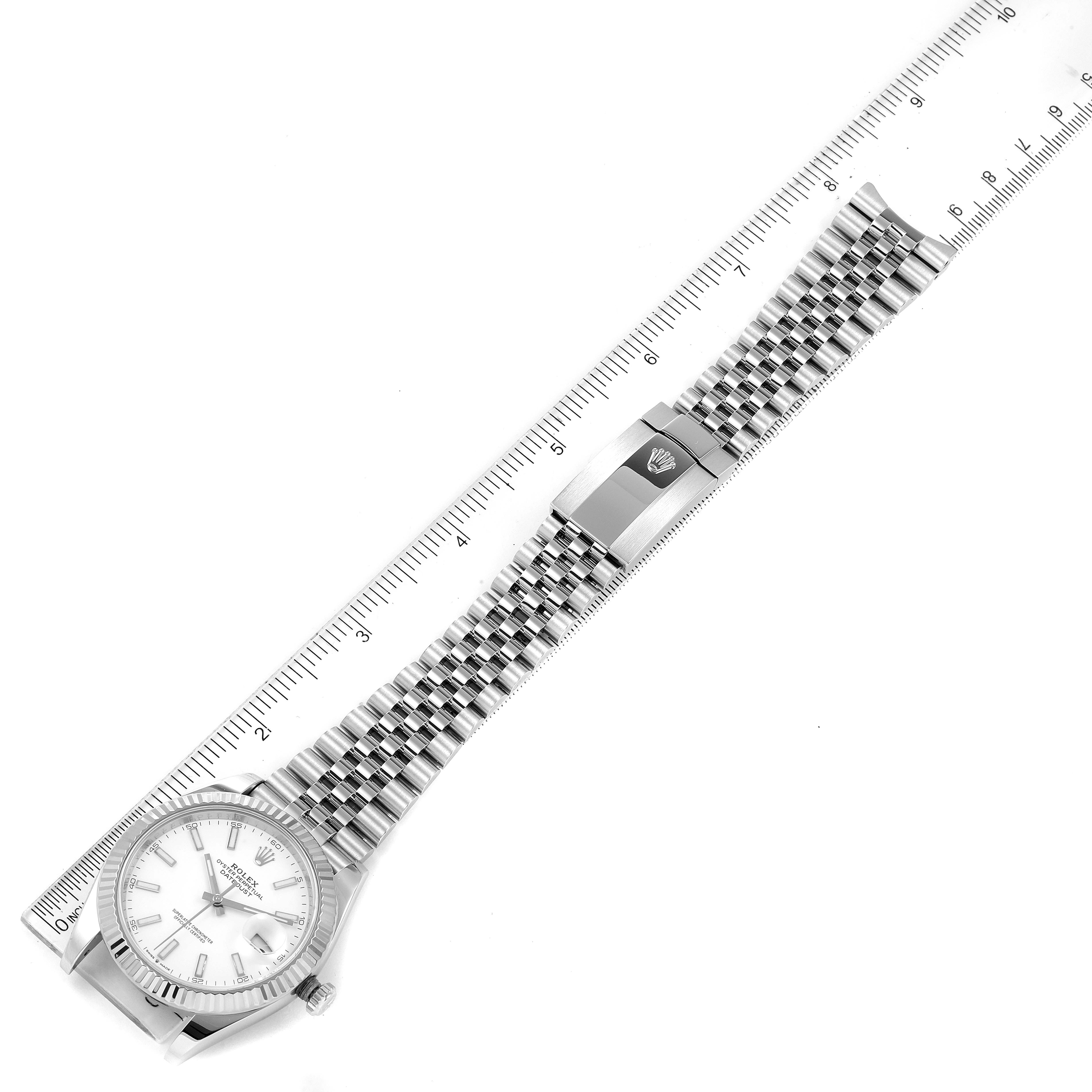 This image shows a top-down view of a Rolex Datejust 41 126334 Men
s Stainless Steel White Dial 126334 Men
s Stainless Steel White Dial watch, including the dial, bracelet, and clasp, with a ruler for scale.