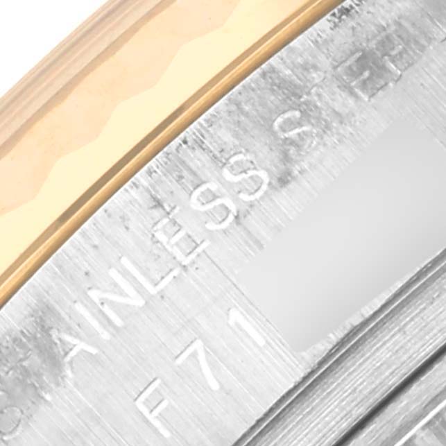 The image shows a close-up of the edge and partial engraving on the case back of a Rolex Datejust 179173 Women's Steel and Gold (two tone) Champagne Dial 179173 Women's Steel and Gold (two tone) Champagne Dial watch.