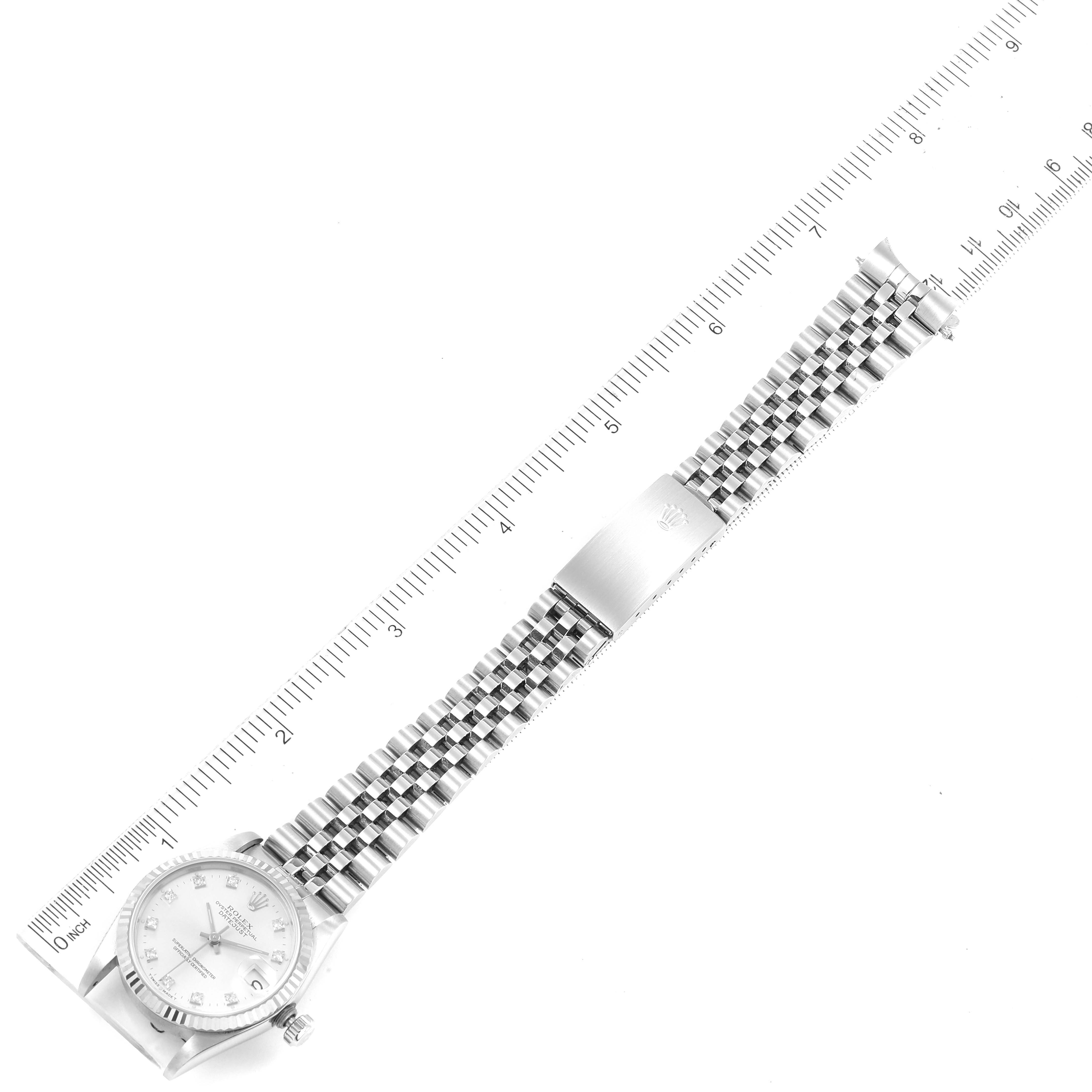 The image shows a top-down view of a Rolex Mid-Size 68274 Women
s Stainless Steel Silver Dial 68274 Women
s Stainless Steel Silver Dial model watch, featuring the face, bracelet, and ruler for size reference.