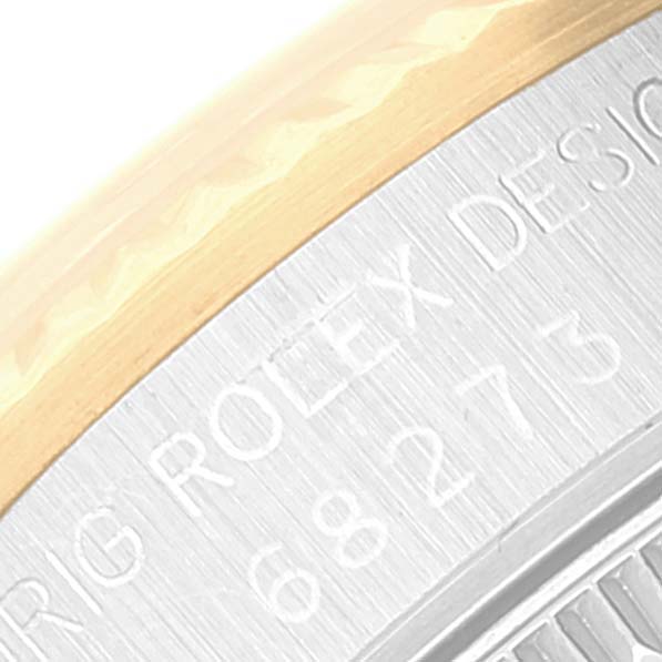 The image shows a close-up of the engraved case back and bezel of a Rolex Mid-Size 68273 Women
s Steel and Gold (two tone) Champagne Dial 68273 Women
s Steel and Gold (two tone) Champagne Dial model watch.