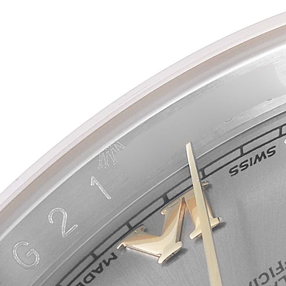 This close-up image of a Rolex Datejust 116233 Men's Steel and Gold (two tone) Grey Dial 116233 Men's Steel and Gold (two tone) Grey Dial watch shows the edge of the dial, part of the chapter ring, and a portion of a hand.