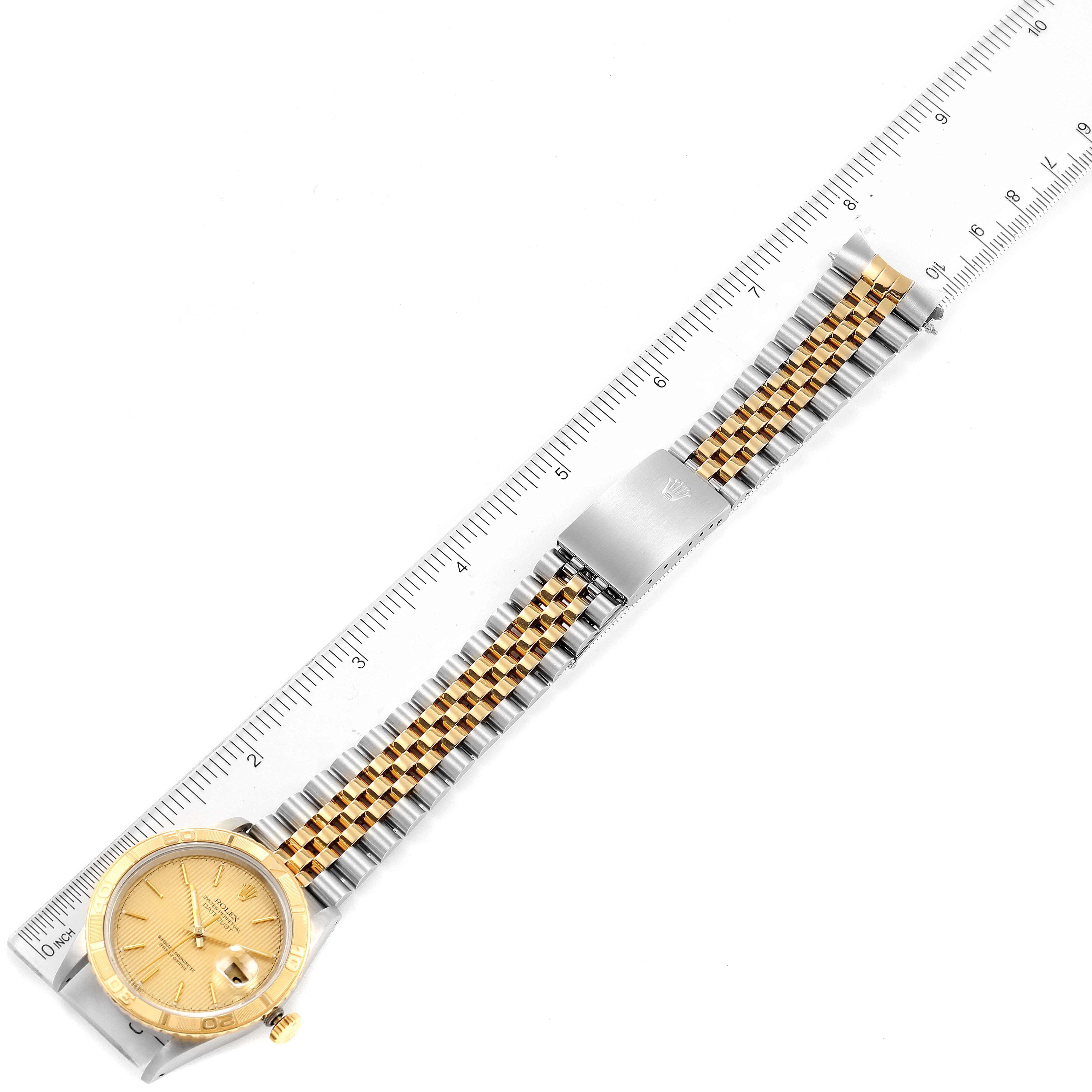 The image shows a Rolex Turn-o-Graph 16263 Men
s Steel and Gold (two tone) Champagne Dial 16263 Men
s Steel and Gold (two tone) Champagne Dial watch with a gold face and a two-tone metal band, aligned next to a ruler for measurement.
