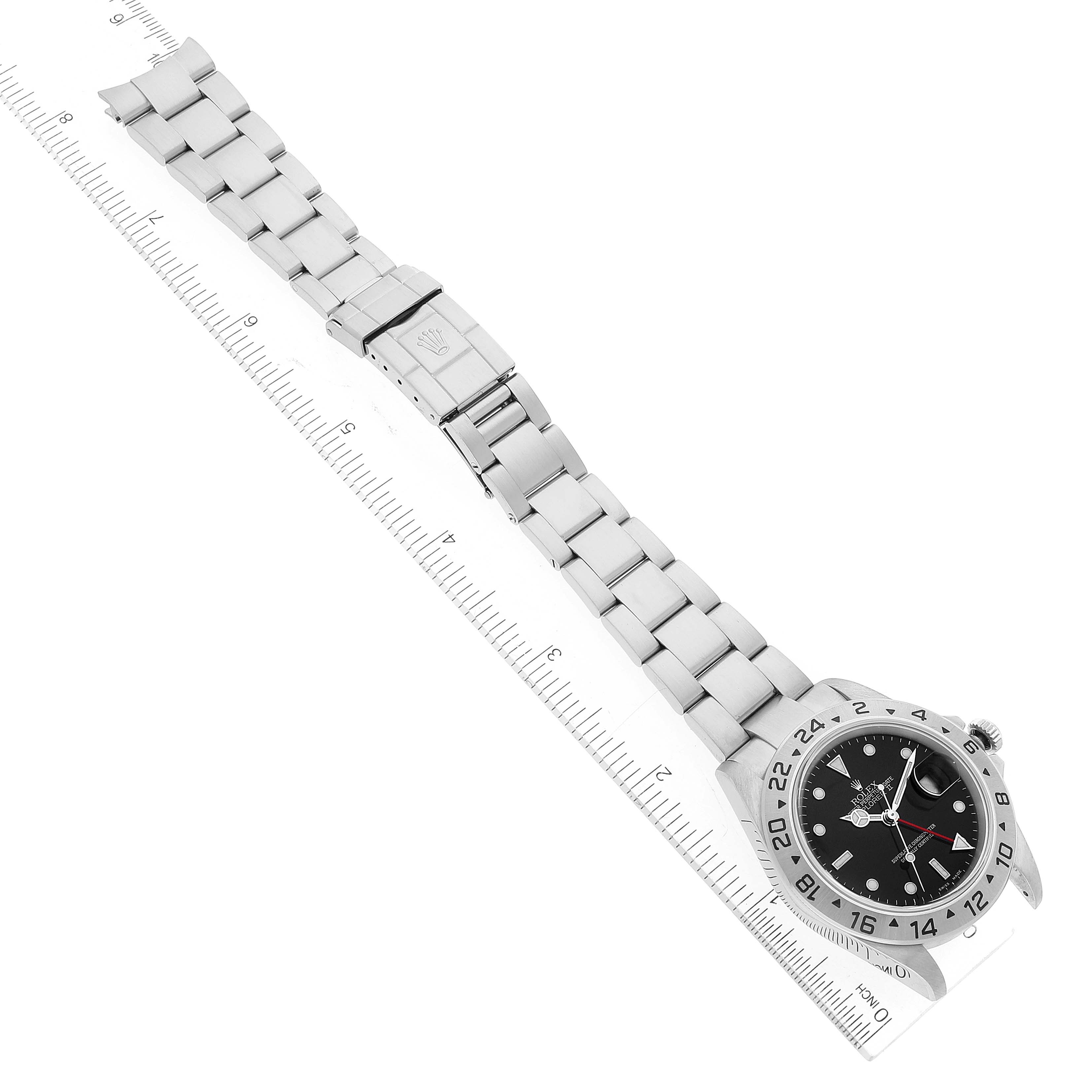 This image shows a Rolex Explorer 16570 Men
s Stainless Steel Black Dial 16570 Men
s Stainless Steel Black Dial watch laid flat with the bracelet extended along a ruler for scale.