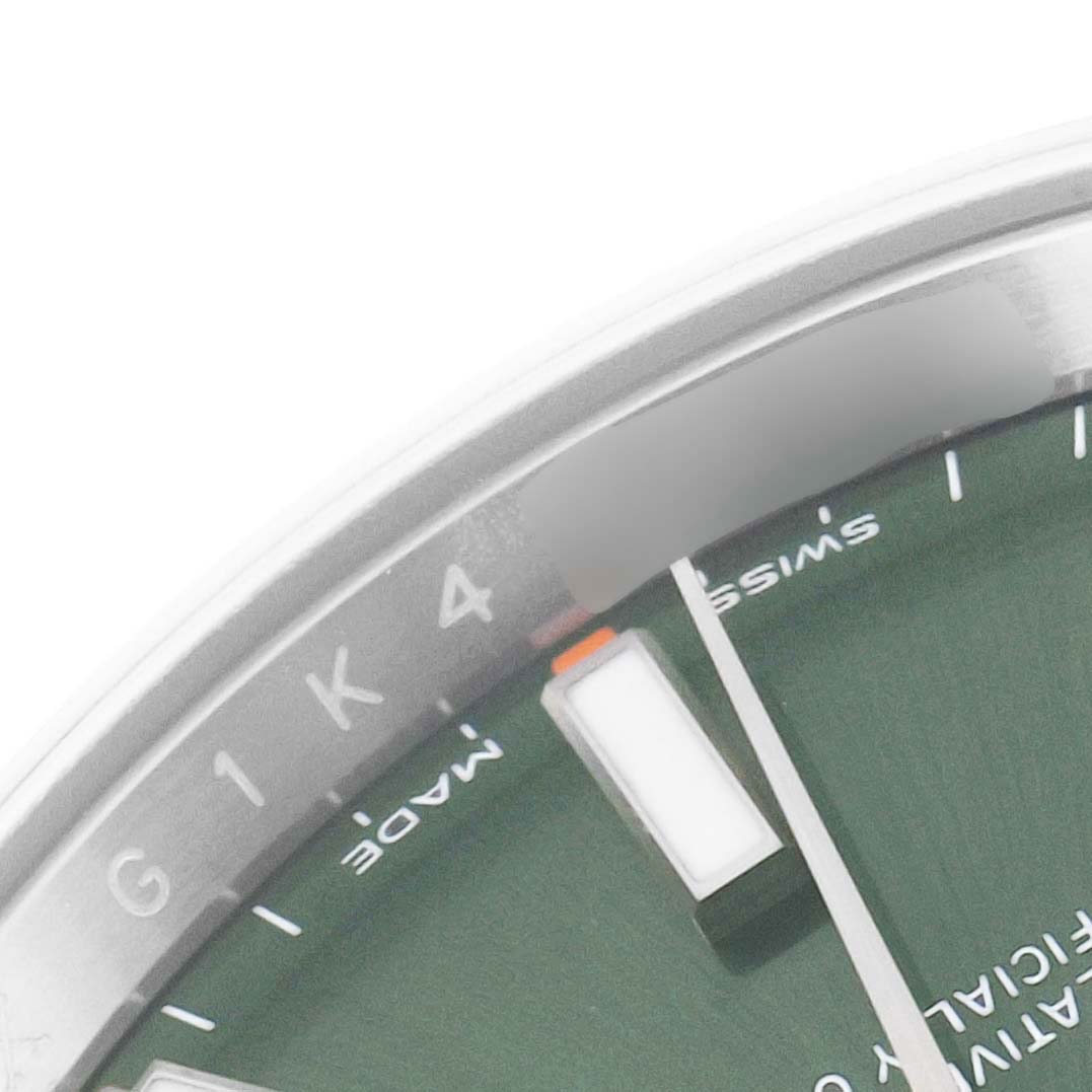 The image shows a close-up of the dial and bezel of a Rolex Oyster Perpetual 114200 Men
s Stainless Steel Green Dial 114200 Men
s Stainless Steel Green Dial watch.