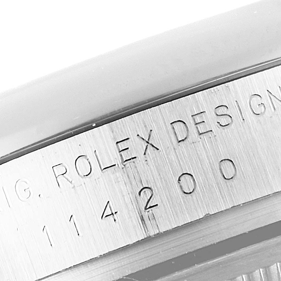 This image shows a close-up of the engraved model number area from the side of a Rolex Oyster Perpetual 114200 Men
s Stainless Steel Green Dial 114200 Men
s Stainless Steel Green Dial watch.