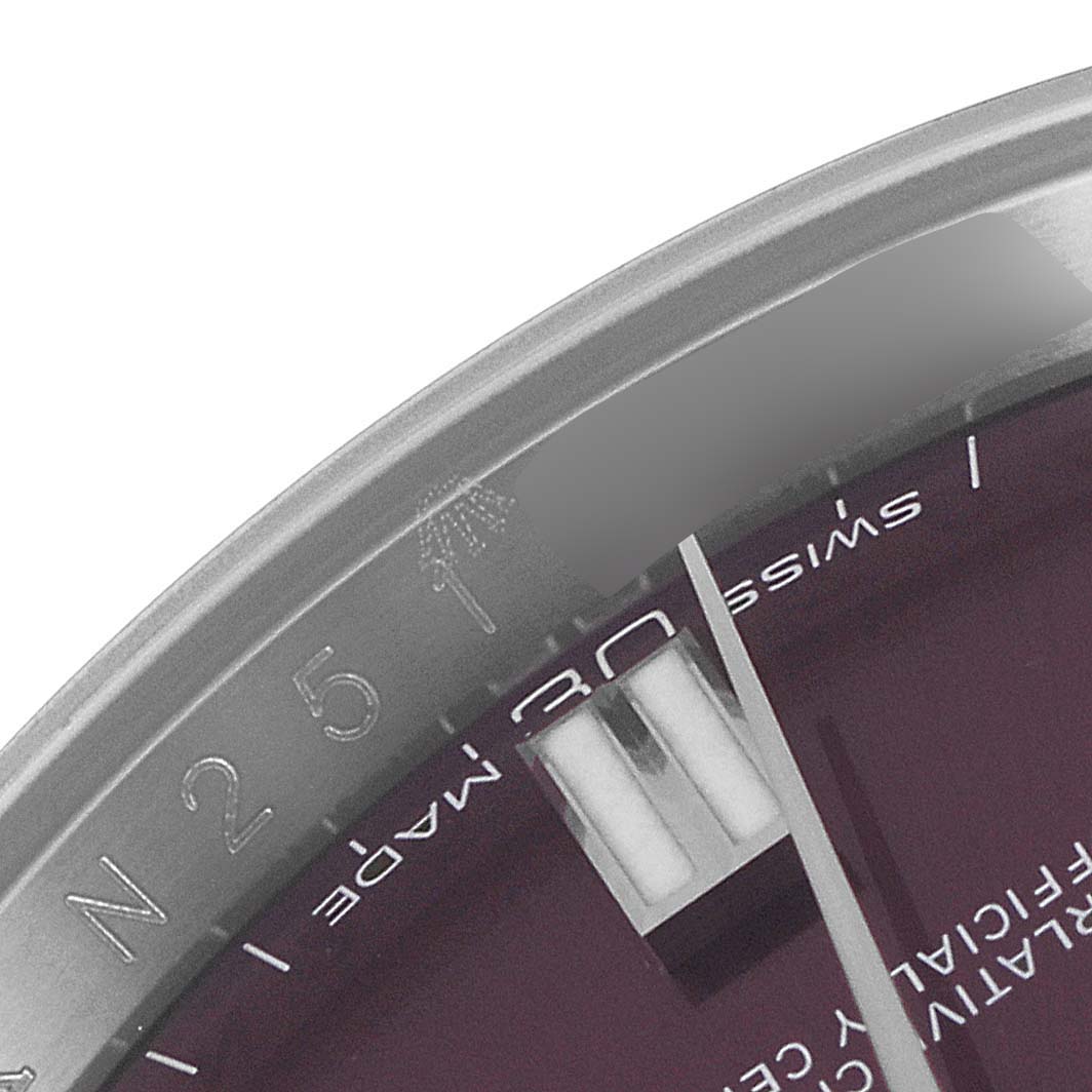 This image shows a partial view of the dial, bezel, and hour marker of a Rolex Oyster Perpetual 116000 Men's Stainless Steel Burgundy Dial 116000 Men's Stainless Steel Burgundy Dial watch.