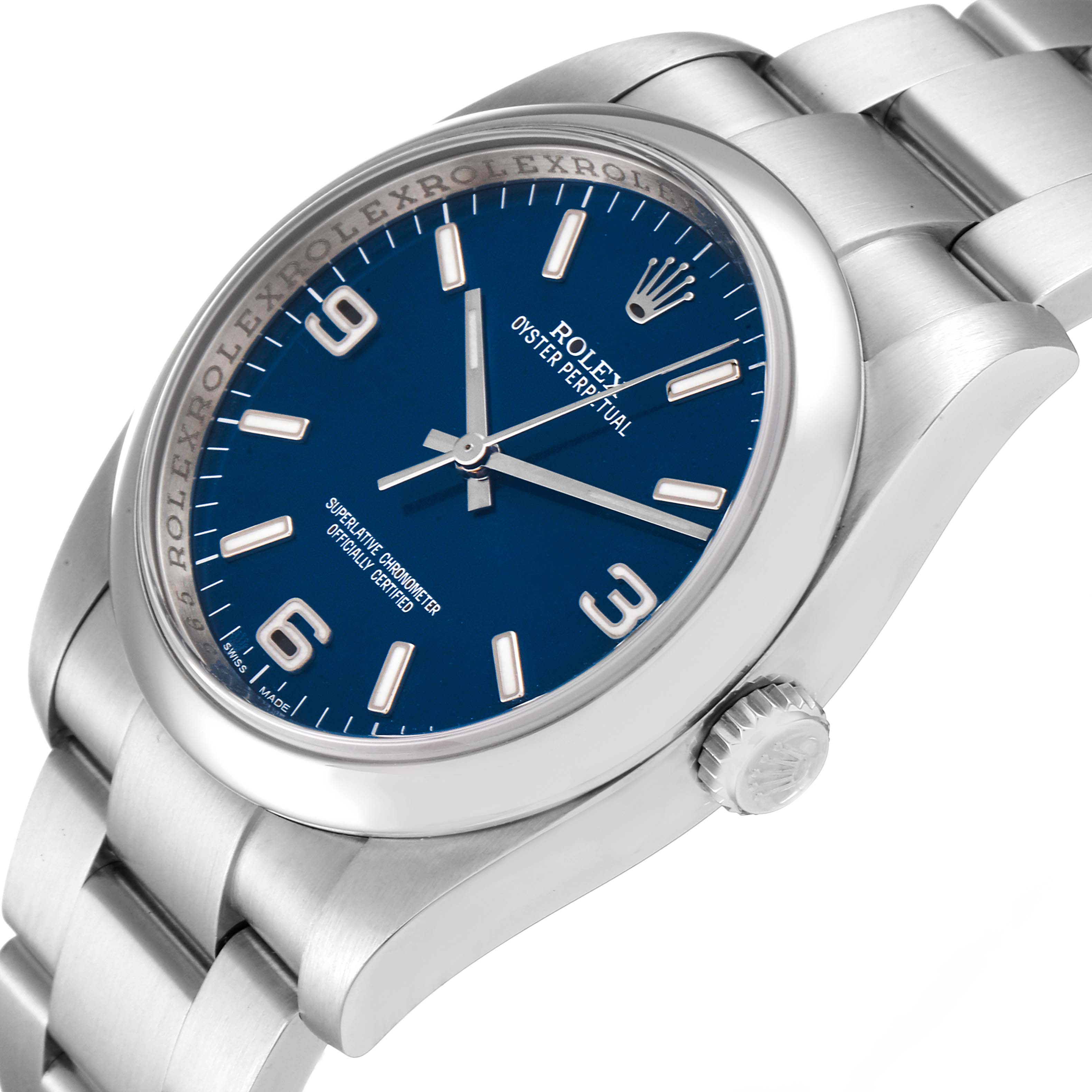The image shows a side angle of a Rolex Oyster Perpetual 116000 Men
s Stainless Steel Blue Dial 116000 Men
s Stainless Steel Blue Dial, displaying its blue dial, crown, and part of the metal bracelet.