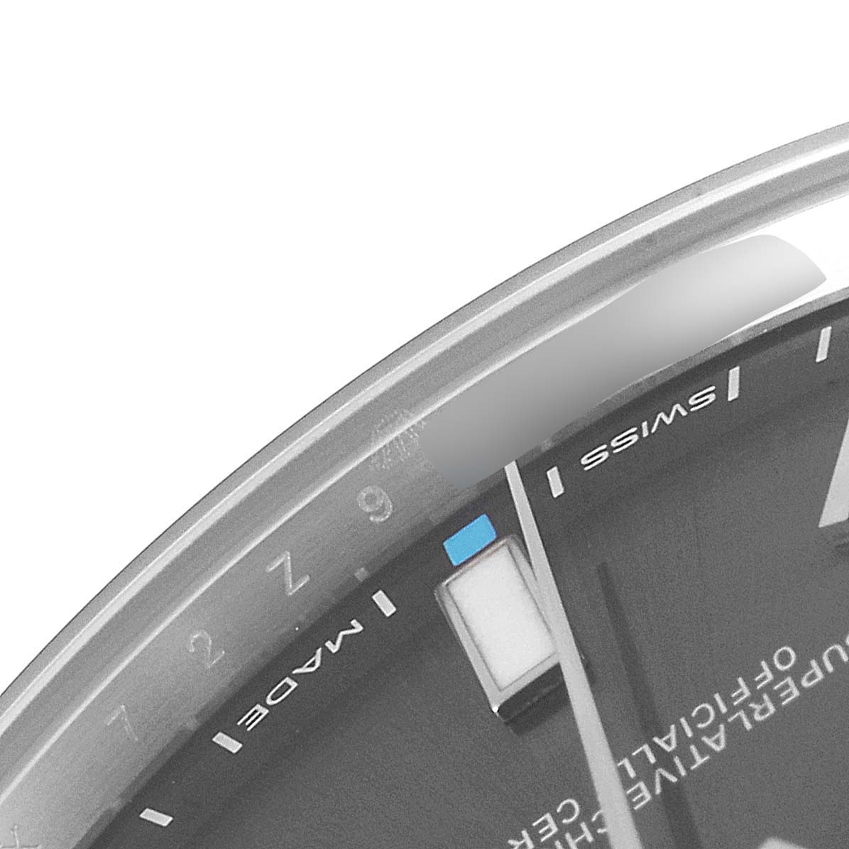 This image shows a close-up of the dial's edge and part of the hands of a Rolex Oyster Perpetual 114300 Men's Stainless Steel Grey Dial 114300 Men's Stainless Steel Grey Dial watch, highlighting the "Swiss Made" marking.