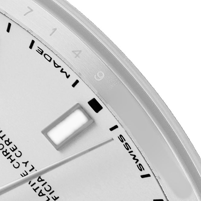 The image shows a close-up of the dial and edge of a Rolex Oyster Perpetual 114300 Men's Stainless Steel Silver Dial, including markers and part of the bezel.