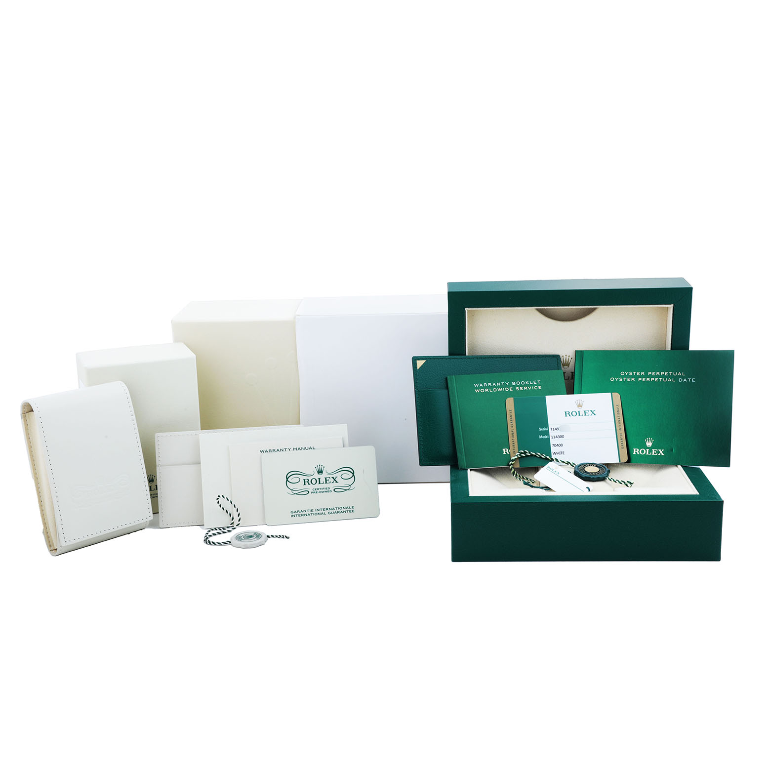 The image shows the packaging and accessories of a Rolex Oyster Perpetual 114300 Men's Stainless Steel Silver Dial, including boxes, manuals, and tags, arranged on a surface.