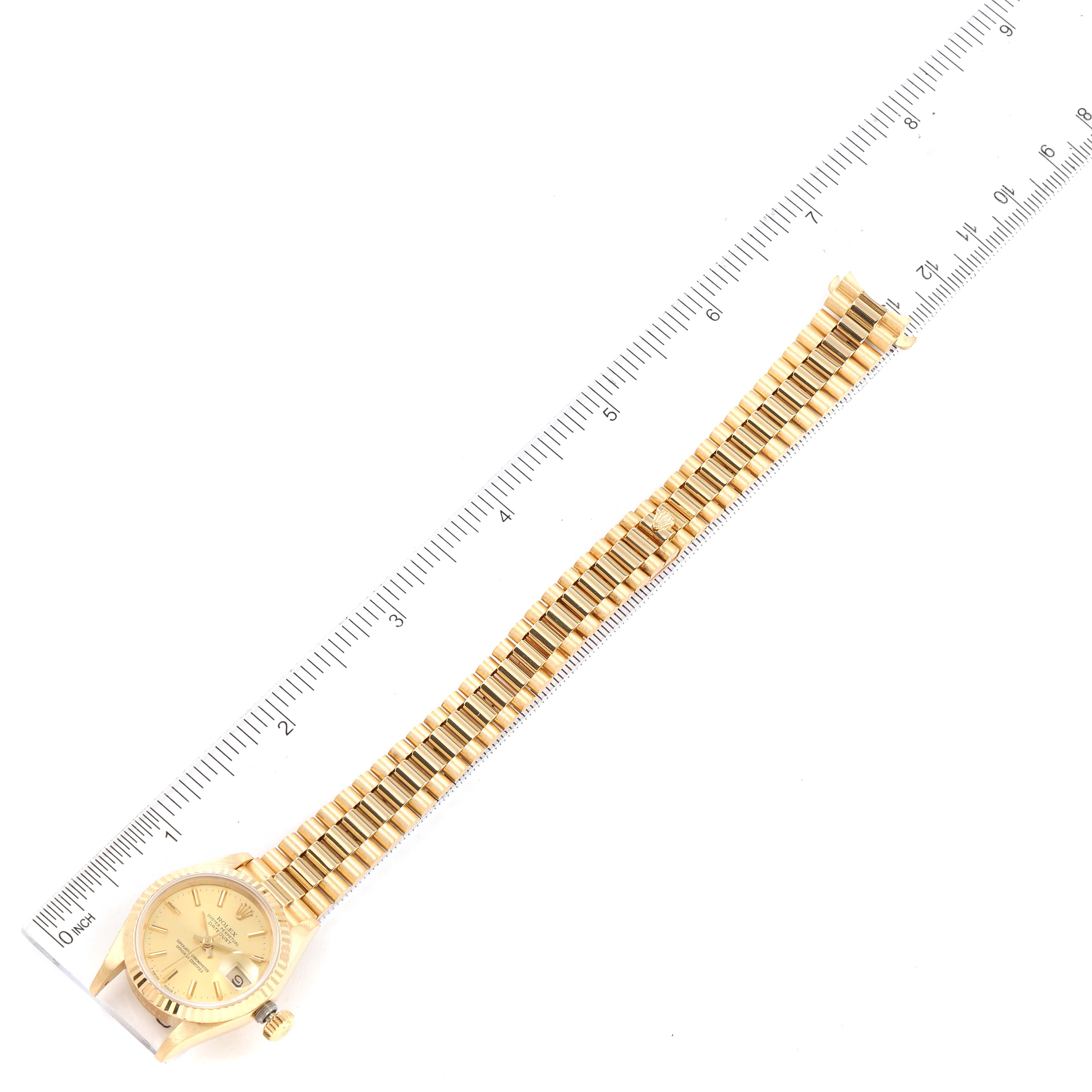 The image shows a Rolex President 69178 Women's Yellow Gold Champagne Dial 69178 Women's Yellow Gold Champagne Dial model watch, laid flat alongside a ruler, displaying the dial and full bracelet.