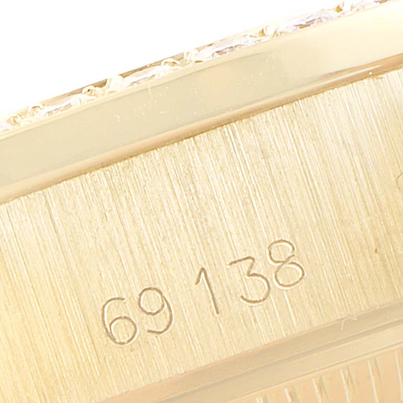This close-up image shows the engraved serial number on the gold case side of a Rolex President 69138 Women's Yellow Gold Champagne Dial 69138 Women's Yellow Gold Champagne Dial model watch.