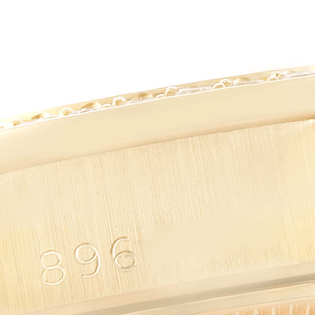 This image shows a close-up of the edge and engraving on the case of a Rolex President 69138 Women's Yellow Gold Silver Dial 69138 Women's Yellow Gold Silver Dial model watch.