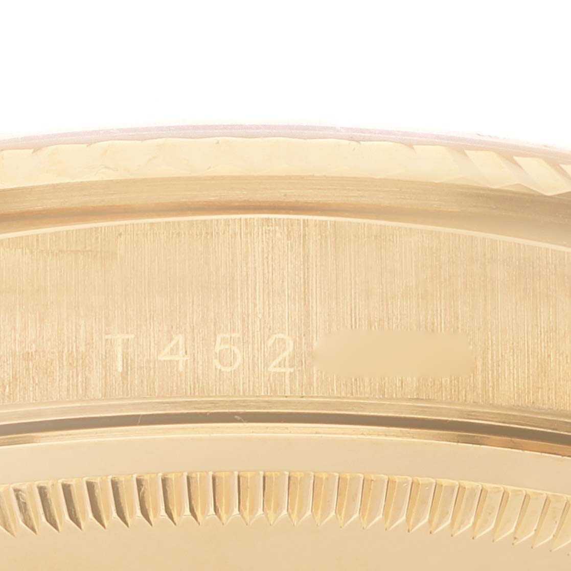 This close-up image shows the engraved serial number and part of the fluted bezel on a Rolex President 18238 Men's Steel and Gold (two tone) Champagne Dial 18238 Men's Steel and Gold (two tone) Champagne Dial model watch.