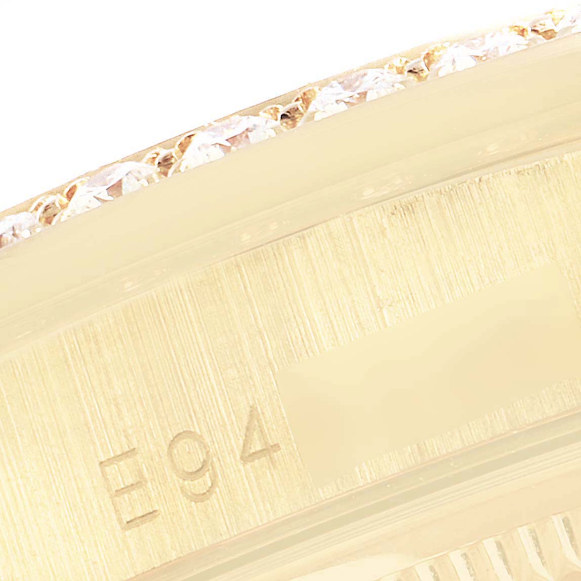 The image shows a close-up of the diamond-studded bezel and part of the engraved edge of a Rolex President 18388 Men's Yellow Gold Champagne Dial 18388 Men's Yellow Gold Champagne Dial model watch.