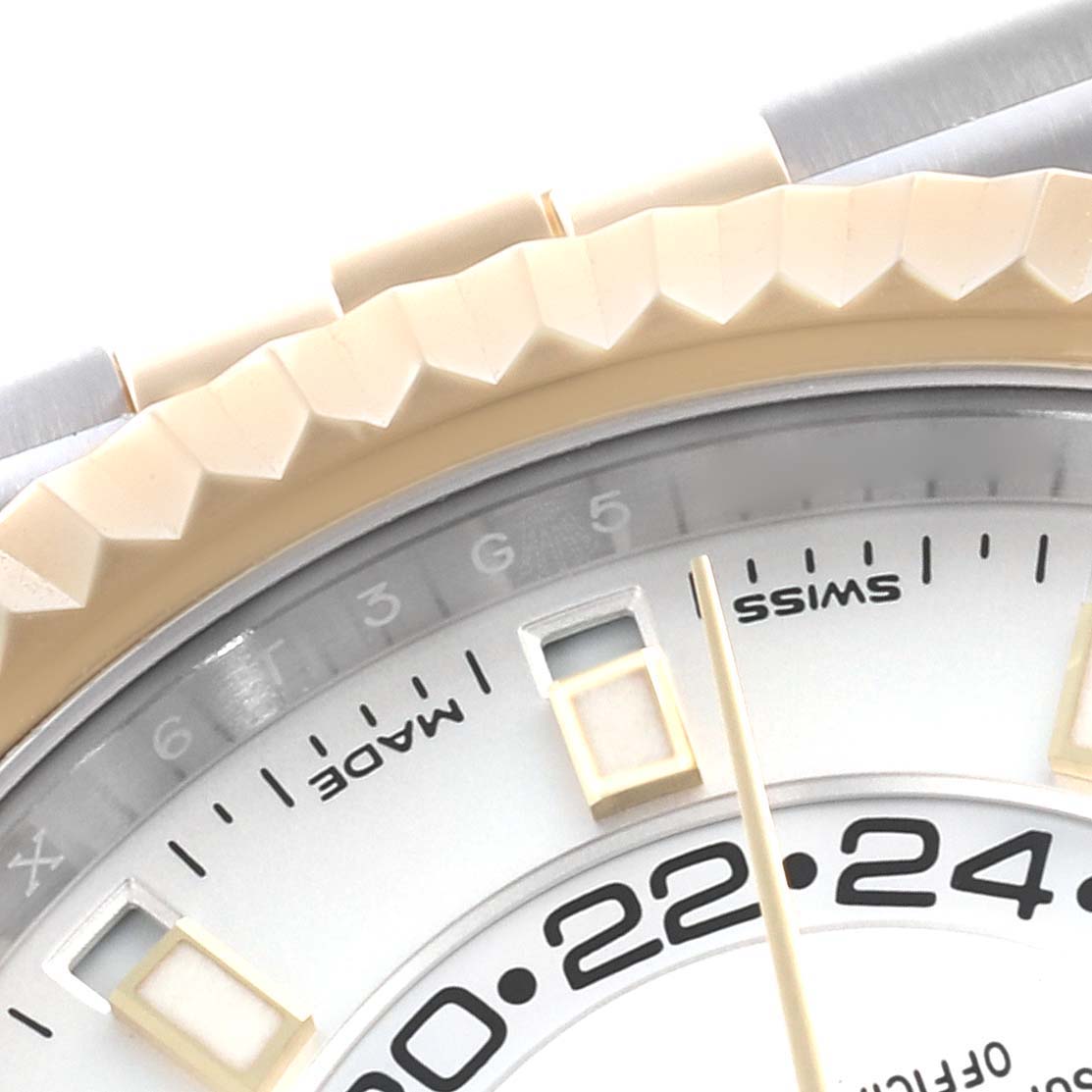 The image shows a close-up of the Rolex Sky-Dweller 326933 Men's Steel and Gold (two tone) White Dial 326933 Men's Steel and Gold (two tone) White Dial's bezel, partial dial, and hour markers.