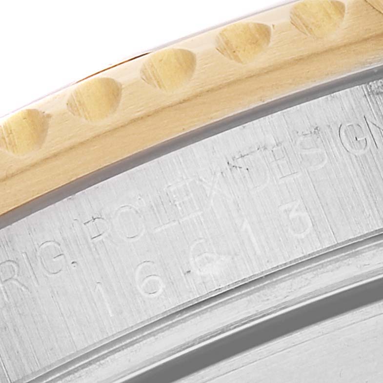 This close-up shows part of the bezel and engraved case back of a Rolex Submariner 16613 Men's Steel and Gold (two tone) Blue Dial 16613 Men's Steel and Gold (two tone) Blue Dial watch.