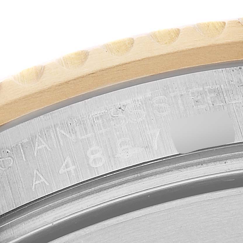 This image shows a close-up of the bezel and part of the case back of a Rolex Submariner 16613 Men's Steel and Gold (two tone) Blue Dial 16613 Men's Steel and Gold (two tone) Blue Dial watch.