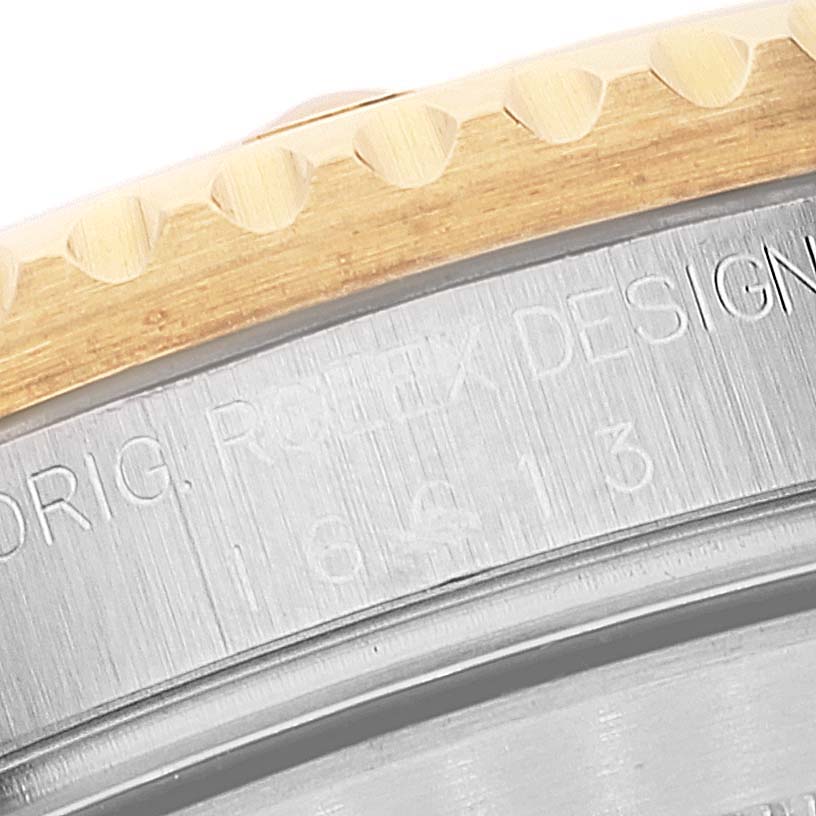 The close-up shows the bezel edge and case engravings of a Rolex Submariner 16613 Men
s Steel and Gold (two tone) Champagne Dial 16613 Men
s Steel and Gold (two tone) Champagne Dial watch.