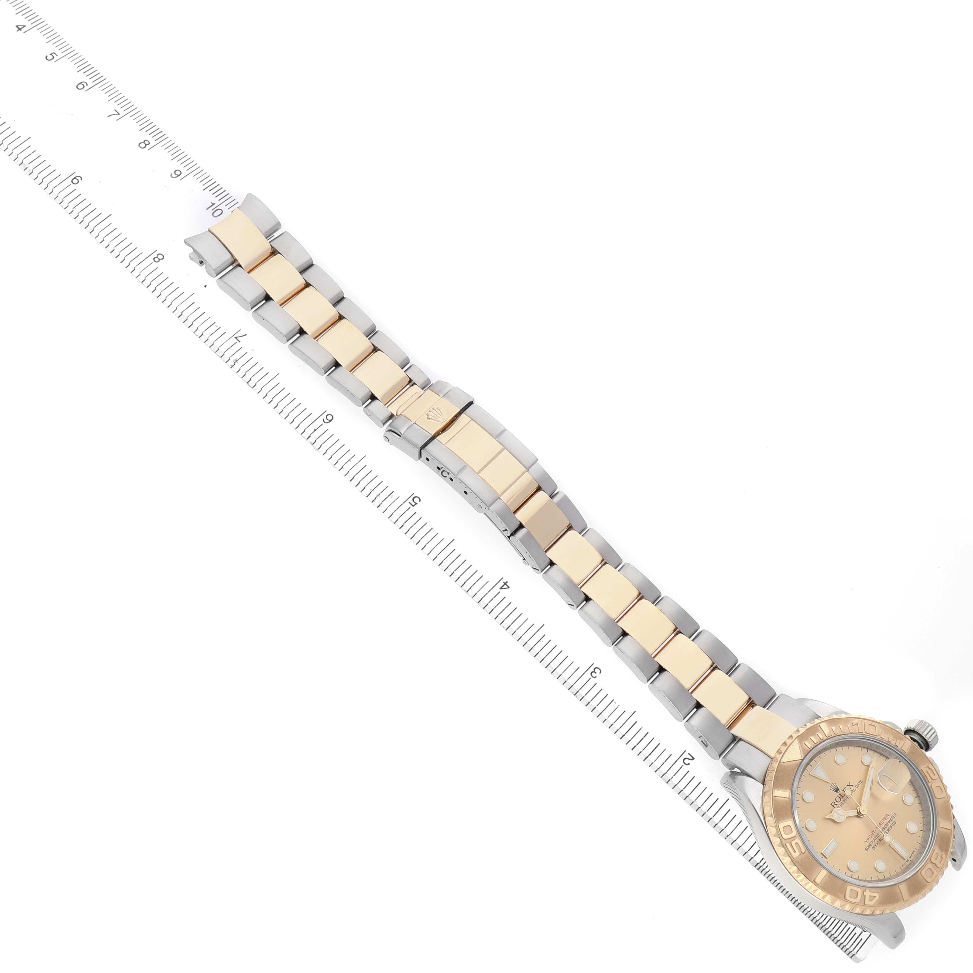 The Rolex Yacht-Master 16623 Men's Stainless Steel Champagne Dial watch is shown from an overhead angle, displaying the face and full bracelet laid next to a ruler.