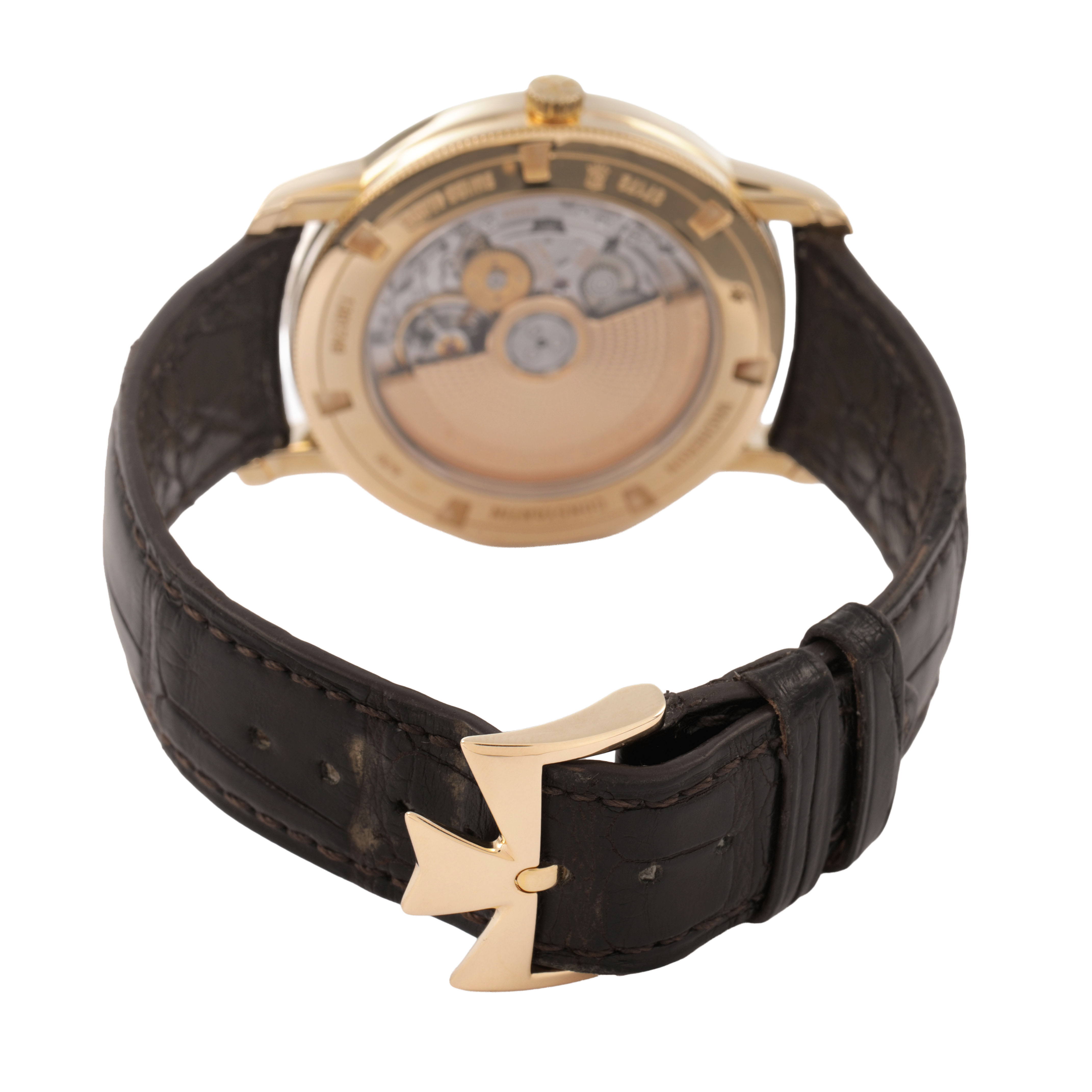 The Traditionnelle model by Vacheron Constantin is shown from the rear, highlighting the movement and the leather strap with gold buckle.