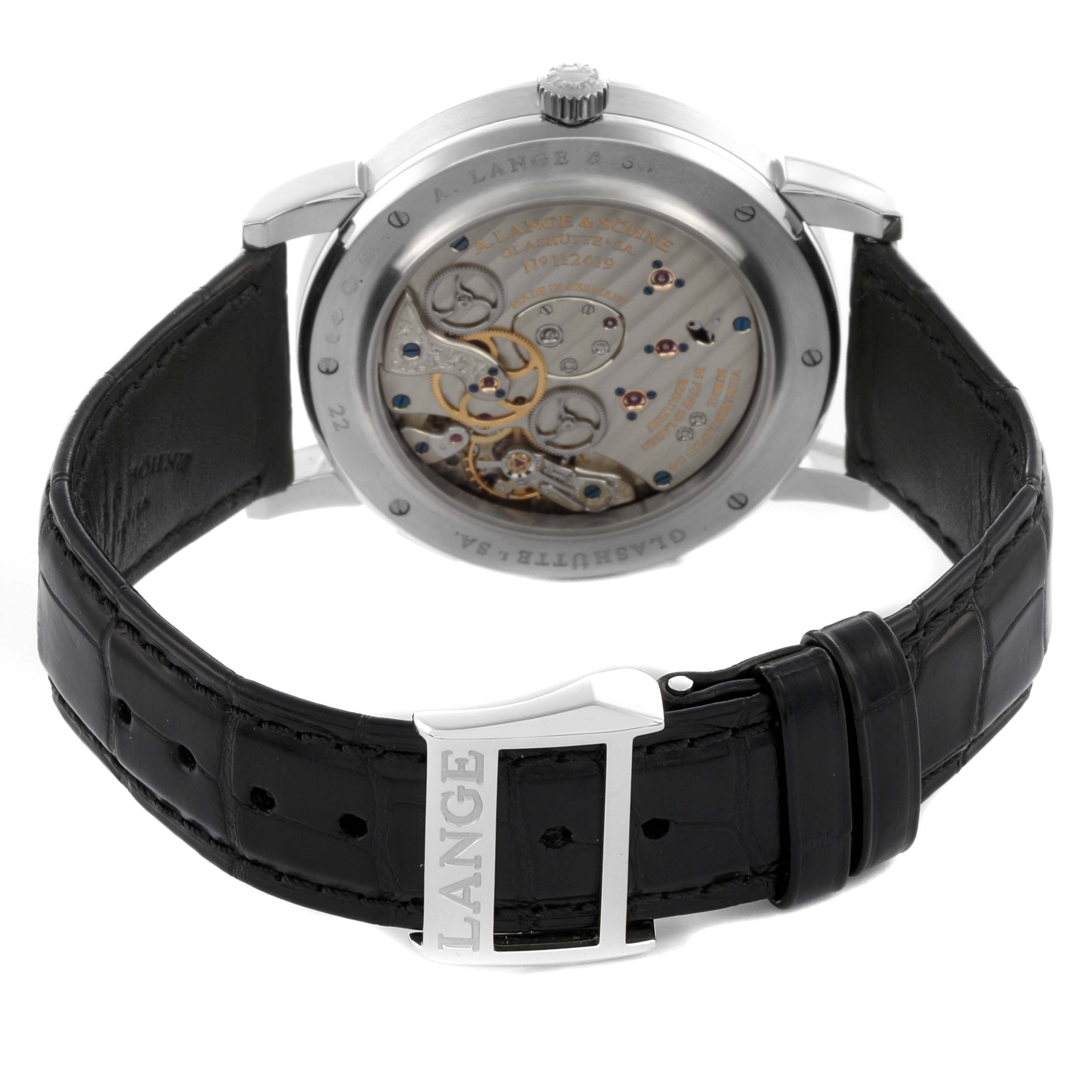 The watch is shown from the back, displaying the movement and mechanism of the A. Lange 
Sohne Lange 1 116.025 Men
s Platinum Silver Dial, with a visible leather strap and buckle.