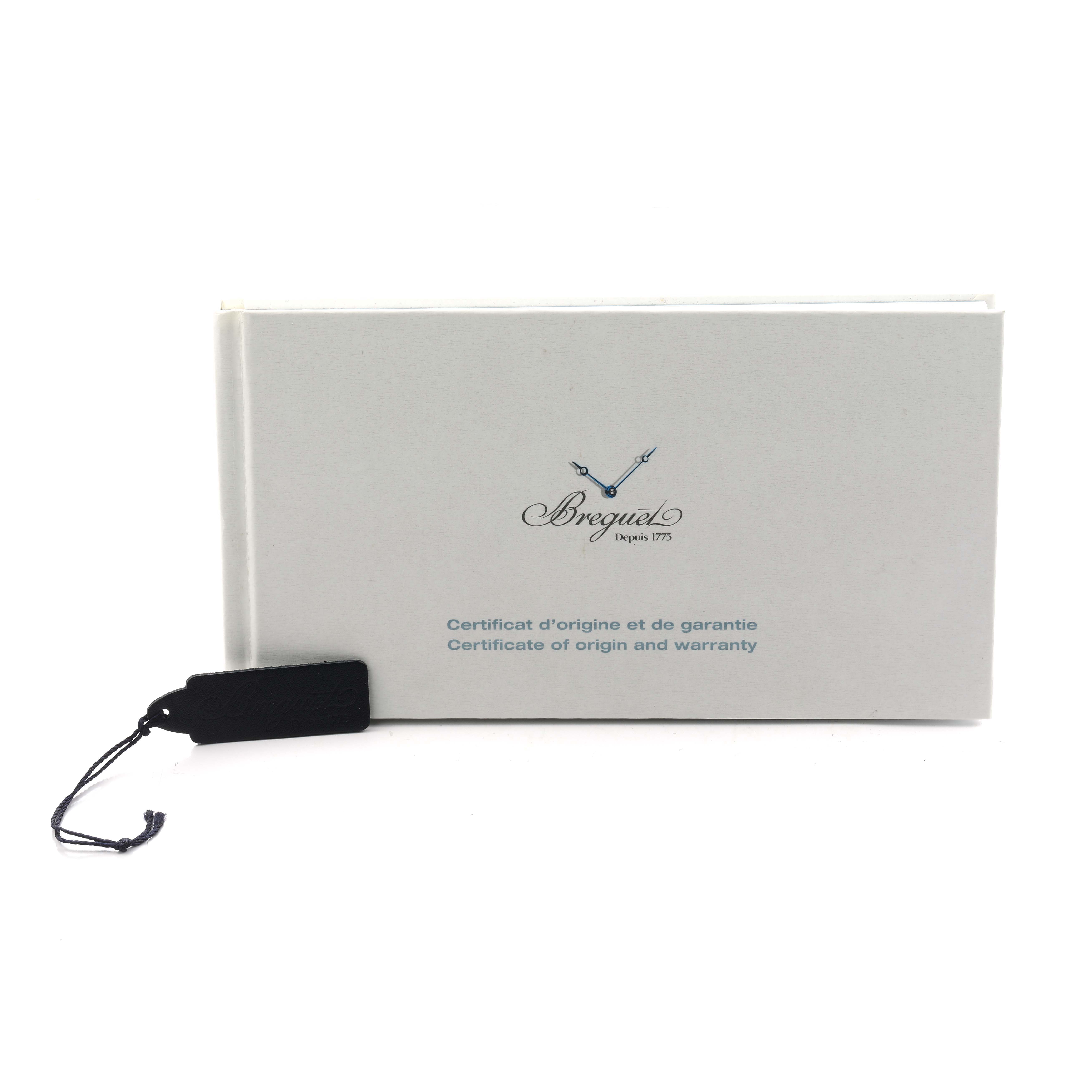 The image shows a warranty and origin certificate for the Breguet Tradition 7097BR/G1/9WU Men
s Rose Gold Transparent Dial model, alongside a black tag with a string.