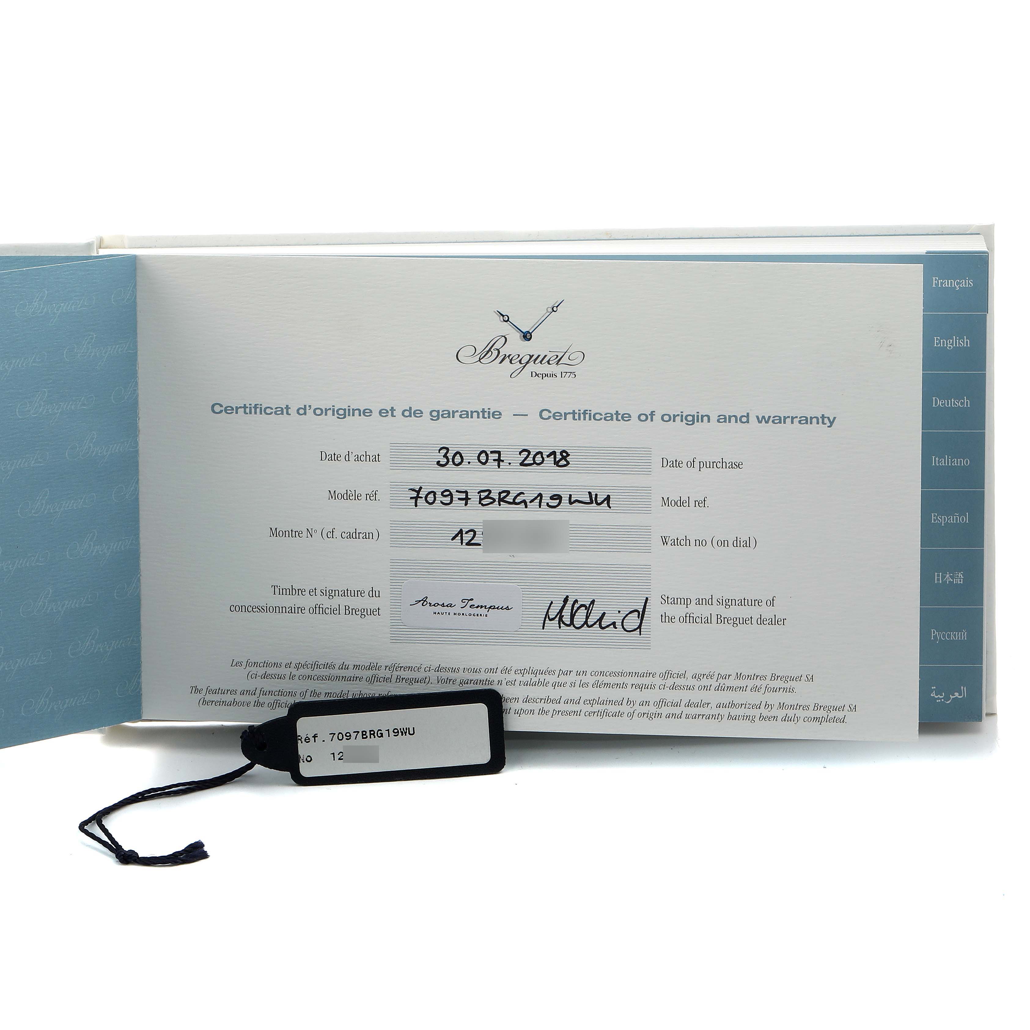 The image shows a Breguet Tradition 7097BR/G1/9WU Men
s Rose Gold Transparent Dial model
s certificate of origin and warranty, featuring text details and a label tag.