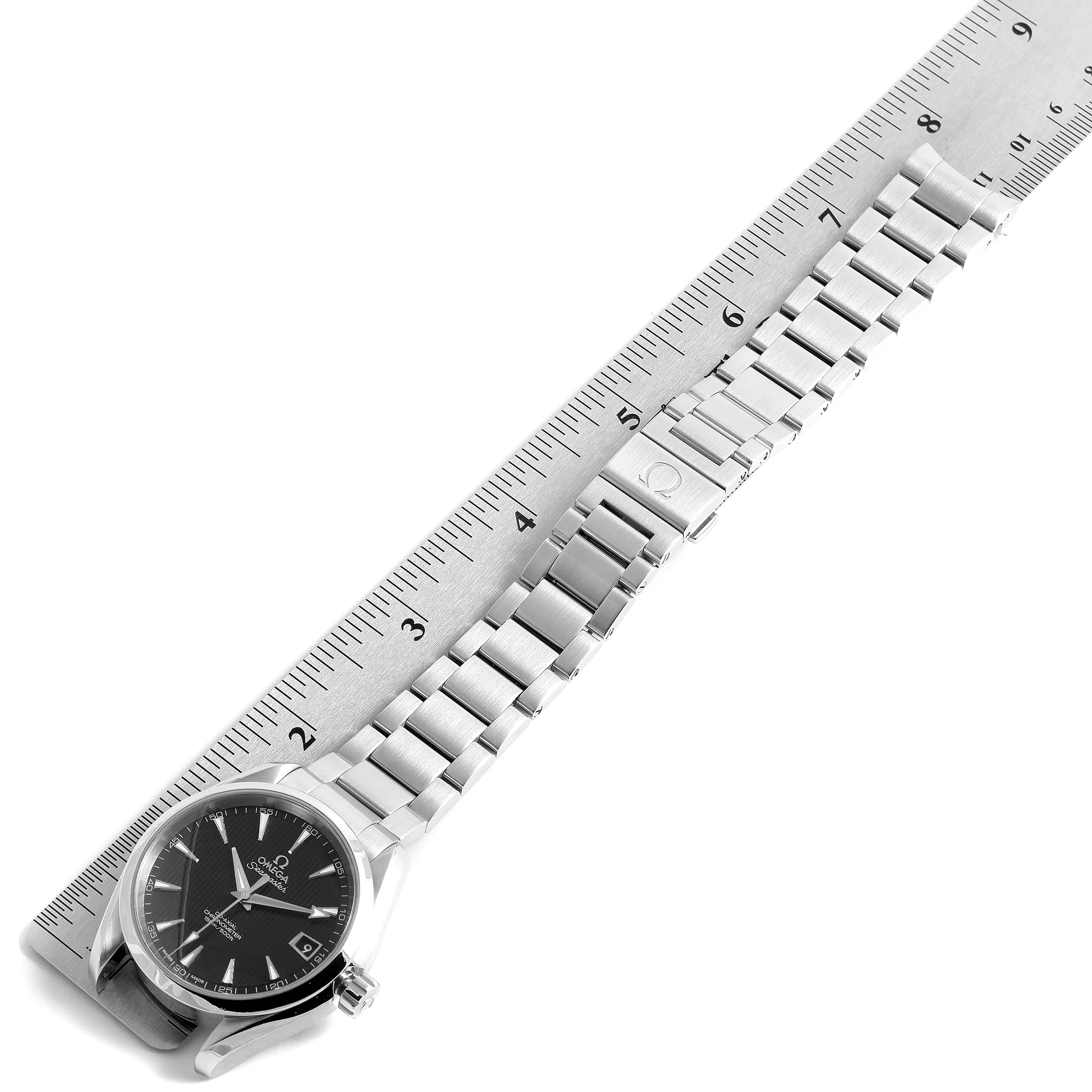 The Omega Aqua Terra 231.10.39.21.01.001 Men's Stainless Steel Black Dial 231.10.39.21.01.001 Men's Stainless Steel Black Dial watch is shown at an angle displaying its face, bracelet, and clasp beside a ruler.
