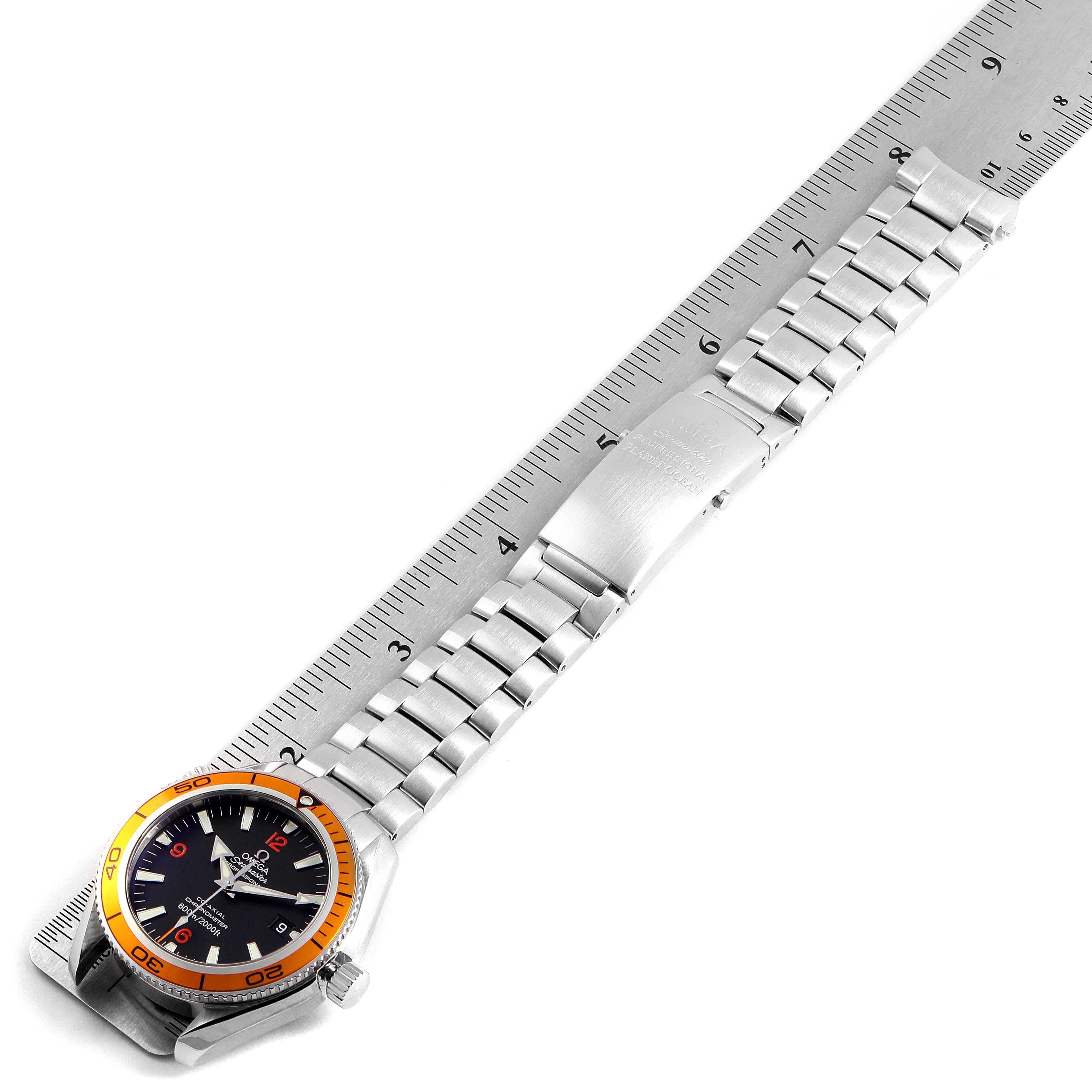 The image shows an Omega Planet Ocean 2209.50.00 Men
s Stainless Steel Black Dial 2209.50.00 Men
s Stainless Steel Black Dial watch laid flat against a ruler, displaying the face and full metal bracelet.