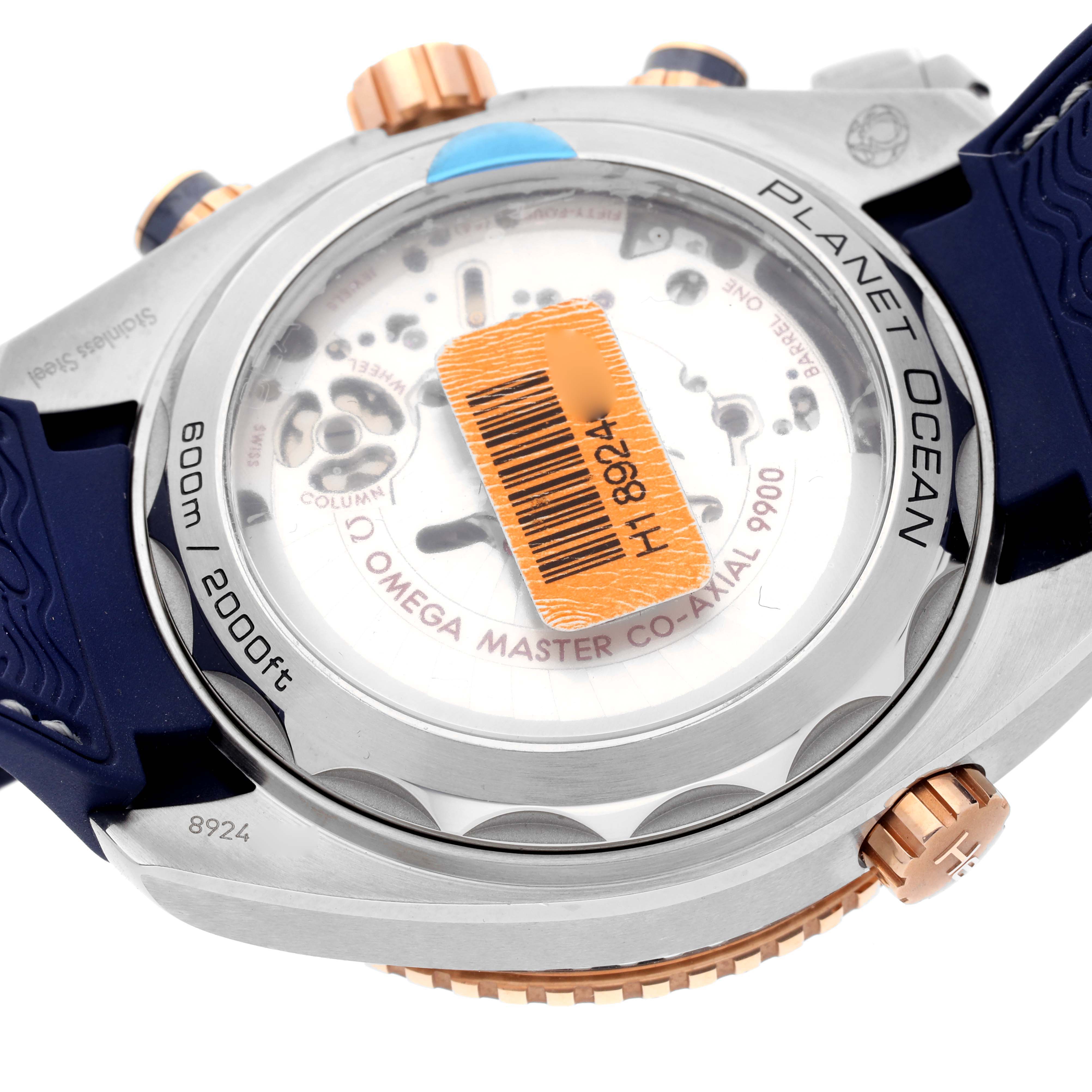 The image shows the back view of the Omega Planet Ocean 215.23.46.51.03.001 Men's Steel and Gold (two tone) Blue Dial 215.23.46.51.03.001 Men's Steel and Gold (two tone) Blue Dial watch, highlighting the movement and water resistance details.