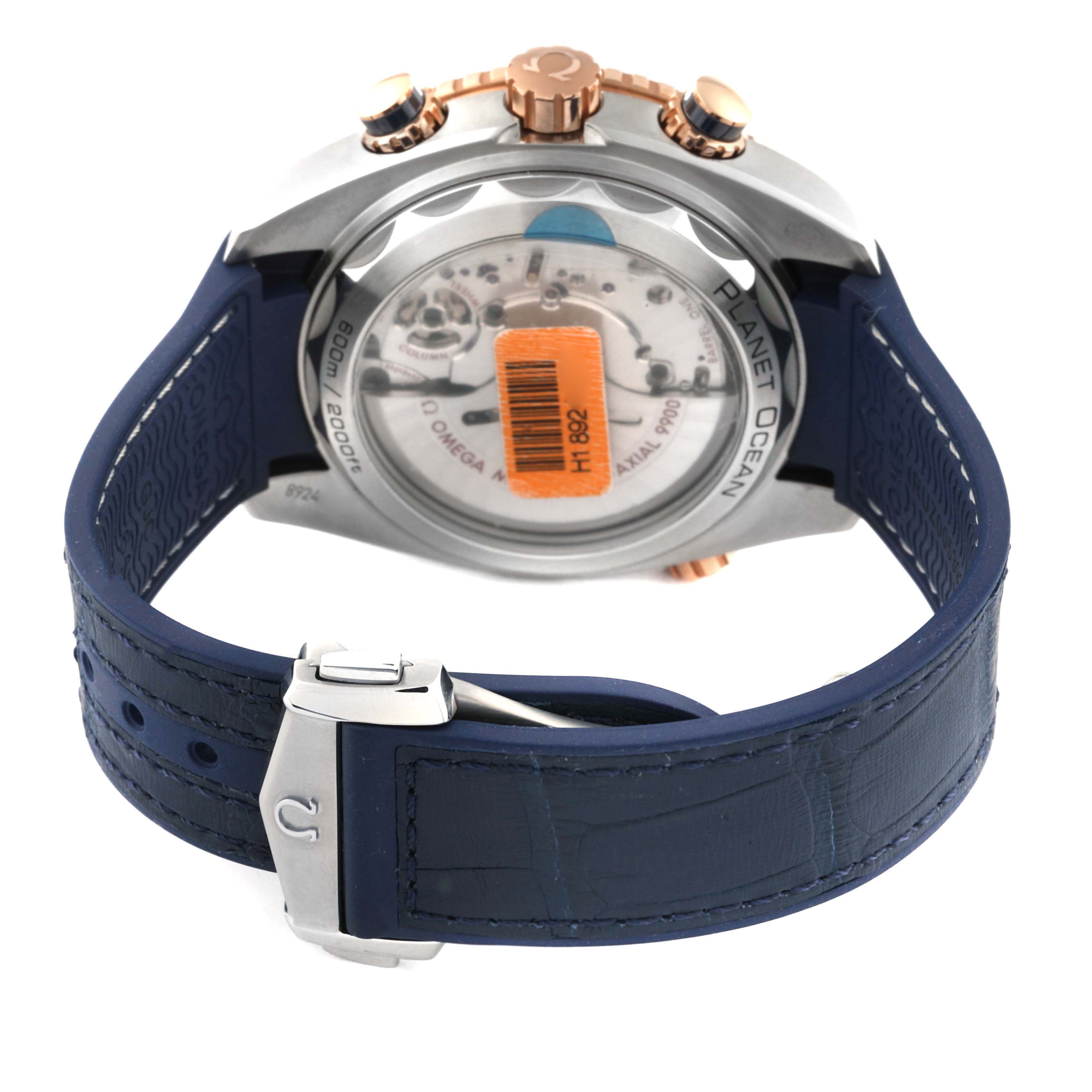 The image shows the back view of the Omega Planet Ocean 215.23.46.51.03.001 Men's Steel and Gold (two tone) Blue Dial 215.23.46.51.03.001 Men's Steel and Gold (two tone) Blue Dial watch, highlighting its case back, blue strap, and clasp.