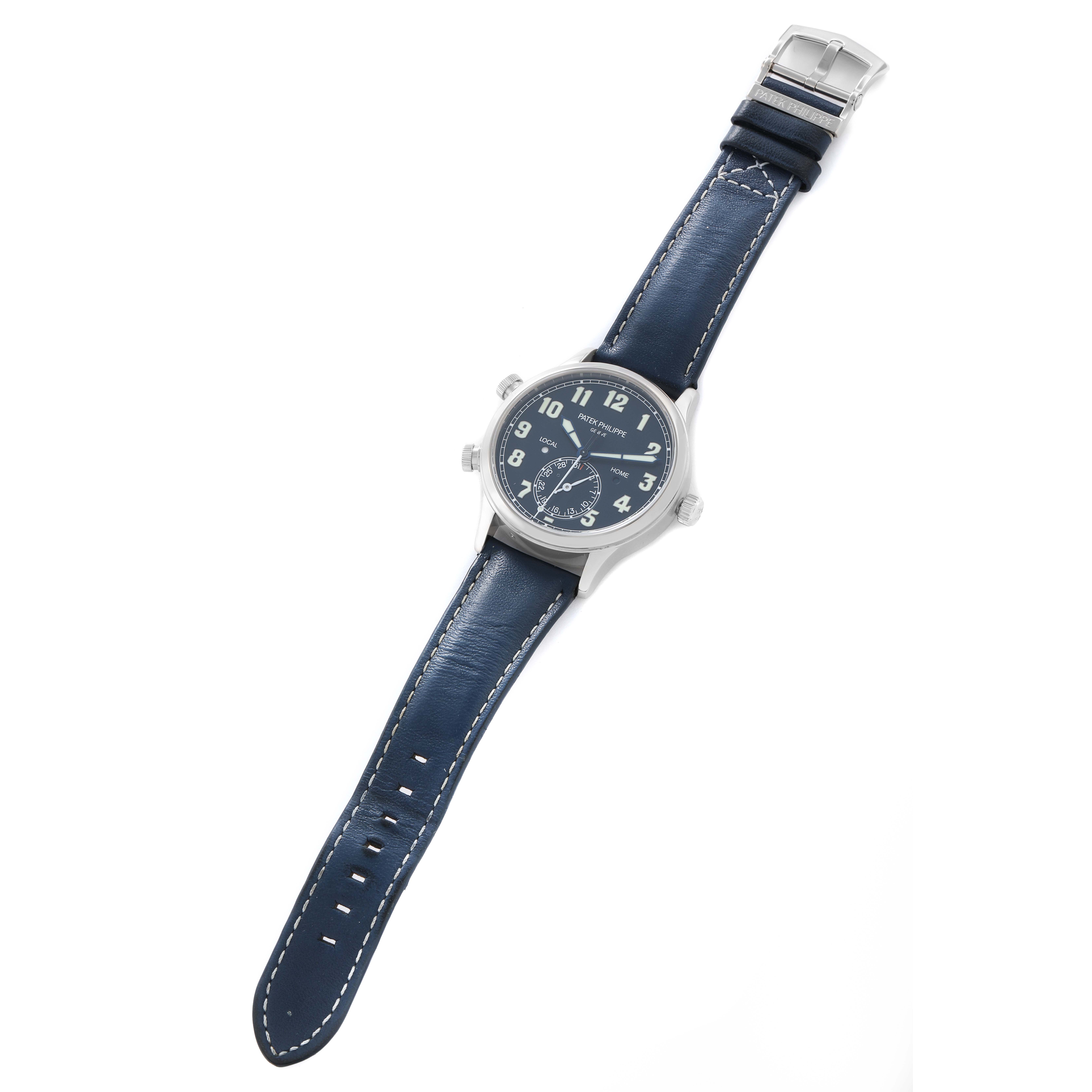 The Patek Philippe Calatrava 5524G Men
s White Gold Blue Dial watch is shown from a top-down angle, displaying the dial, case, and blue leather strap with buckle.