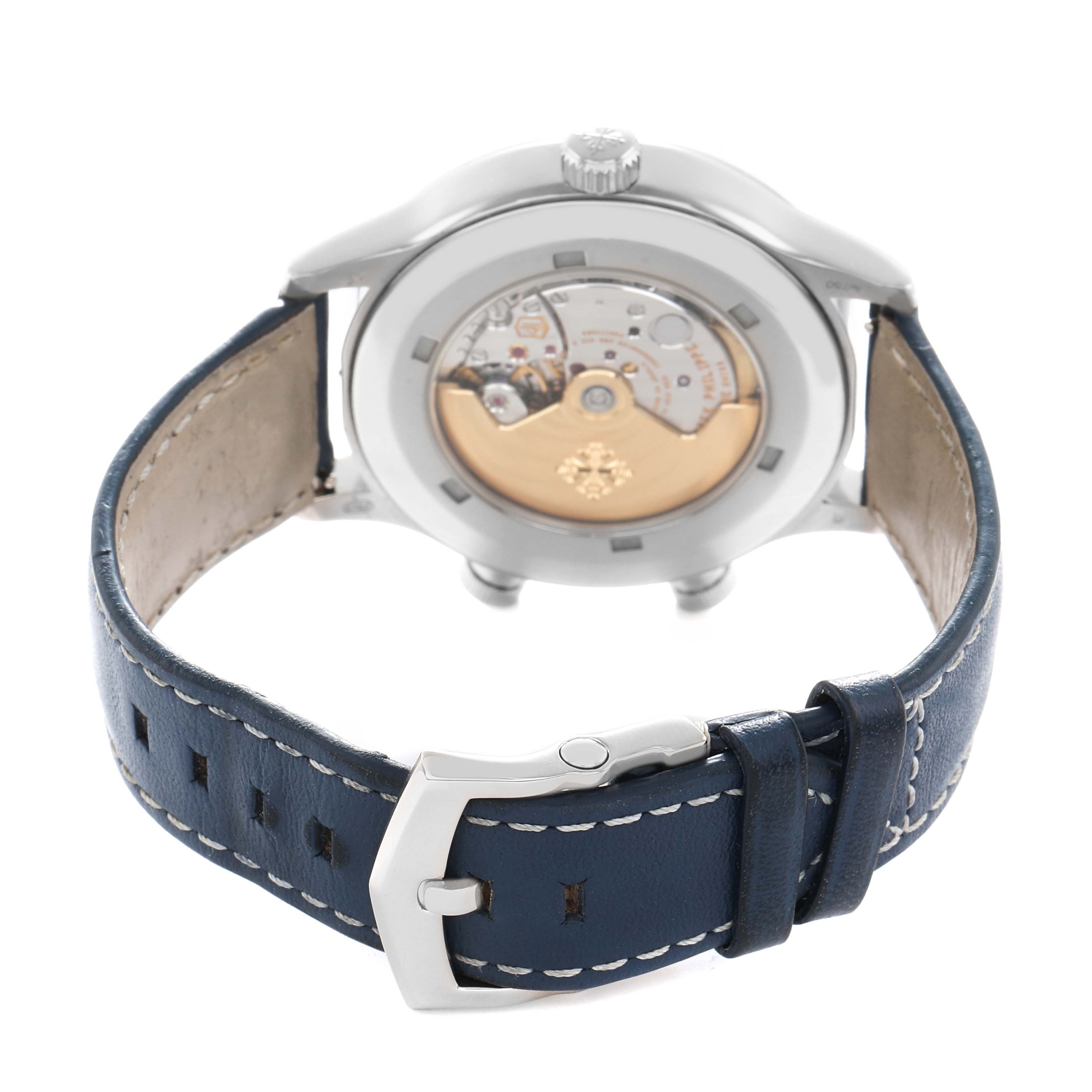 The image shows the back of a Patek Philippe Calatrava 5524G Men
s White Gold Blue Dial watch with its movement visible and a blue leather strap.